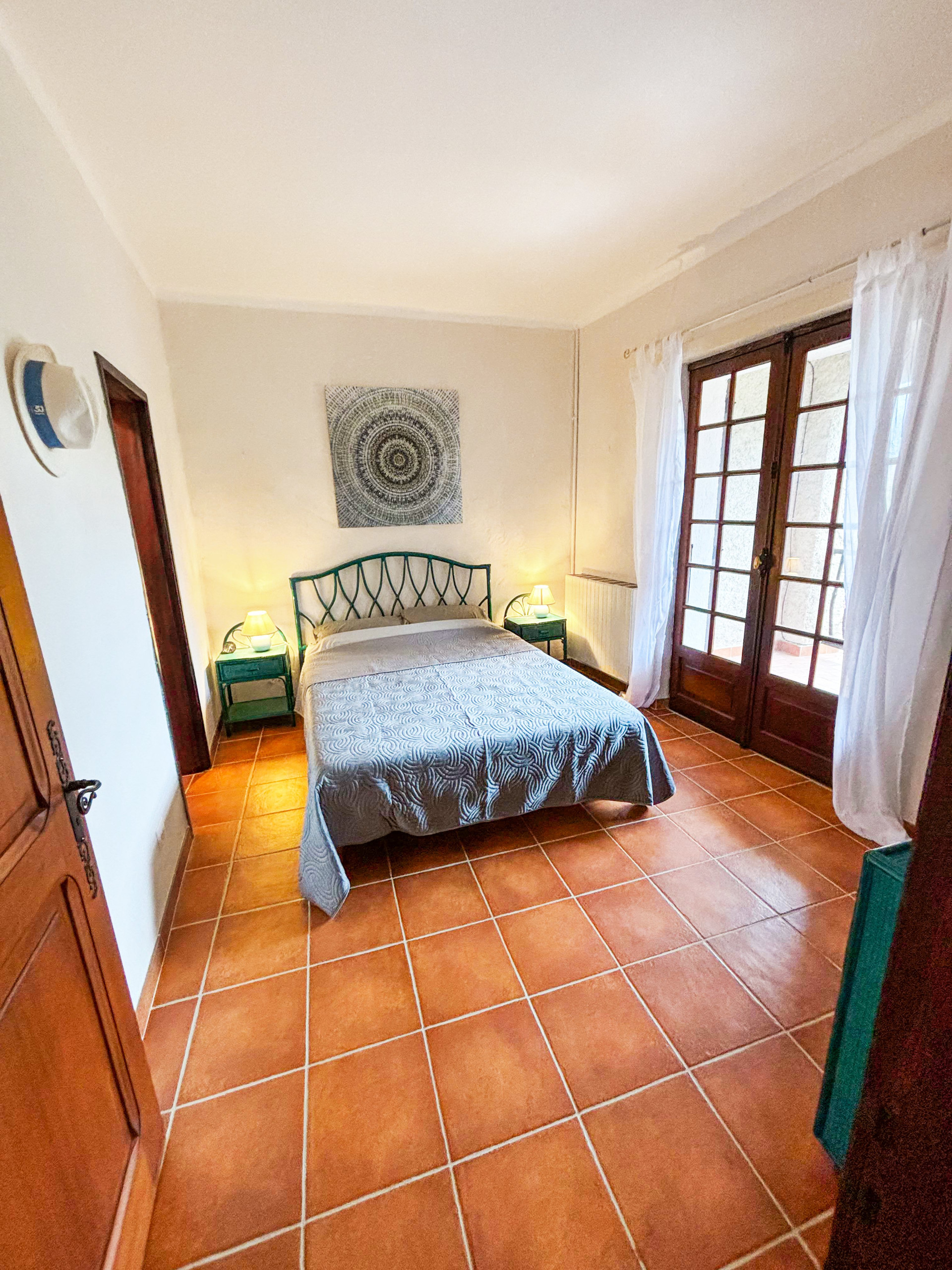 Bedroom with double bed terracotta floor