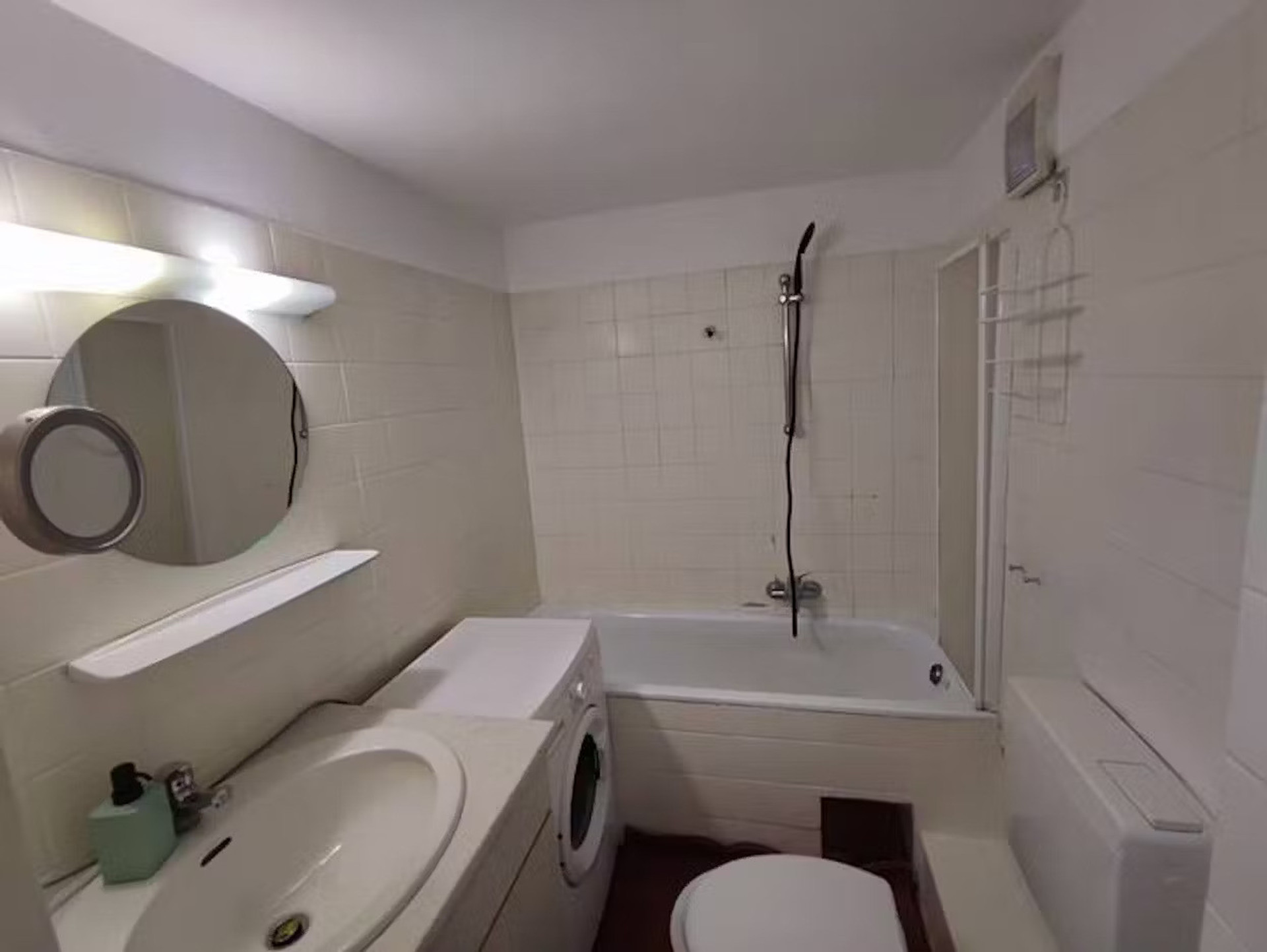 Bathroom with bathtub and washer