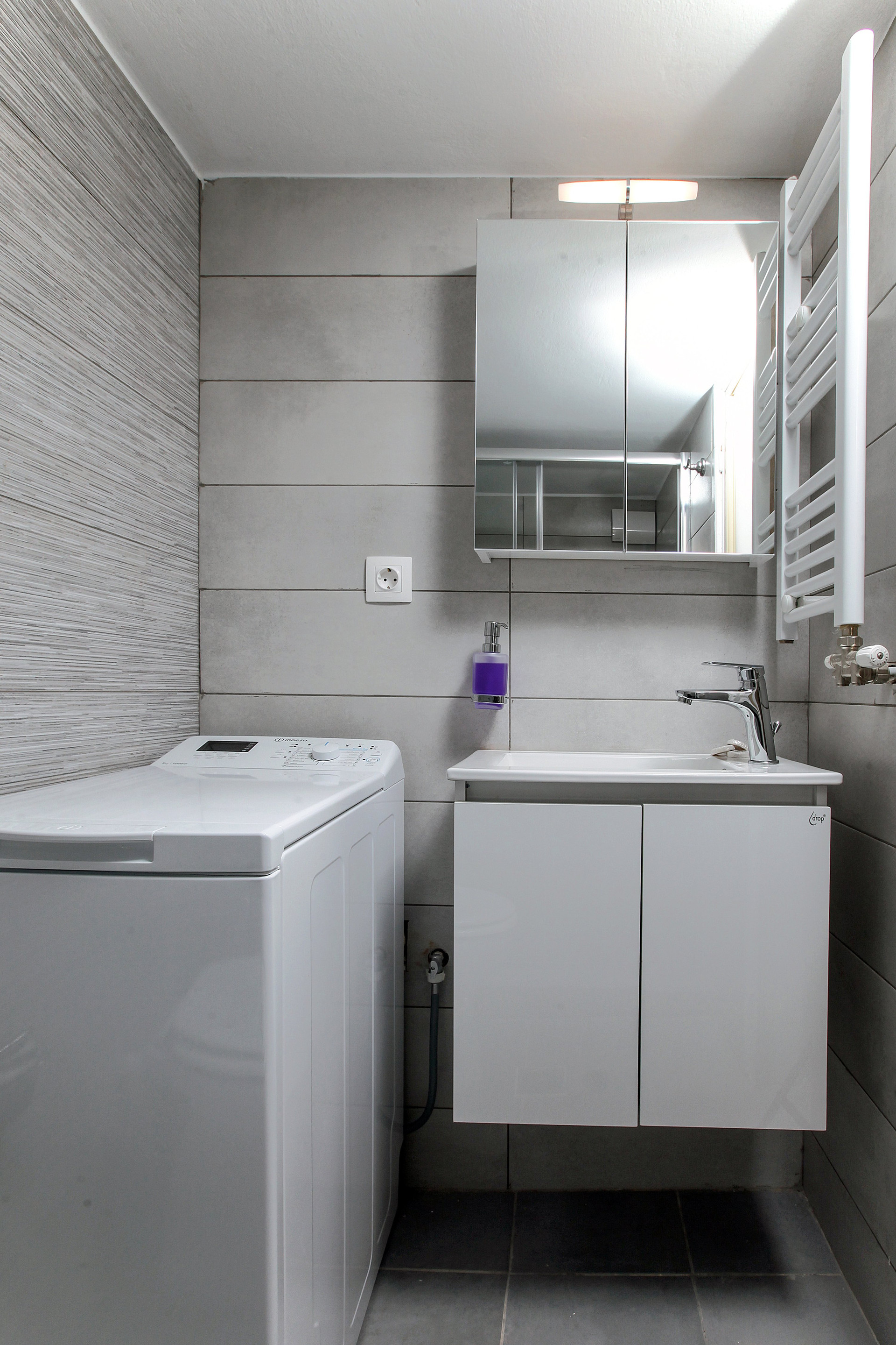 Bathroom with washing machine and vanity