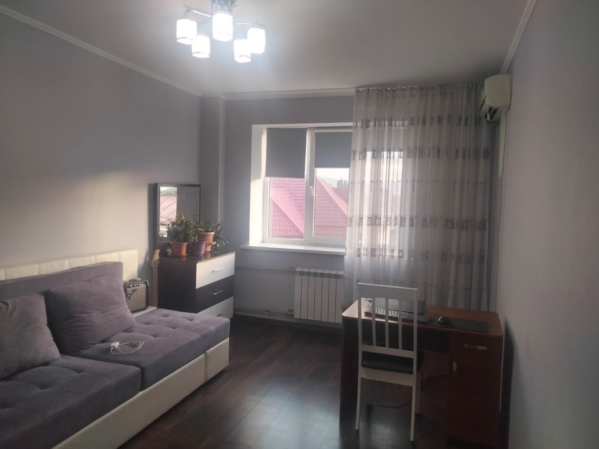 Spacious bedroom with a large sofa-bed, work desk and plenty of natural light.