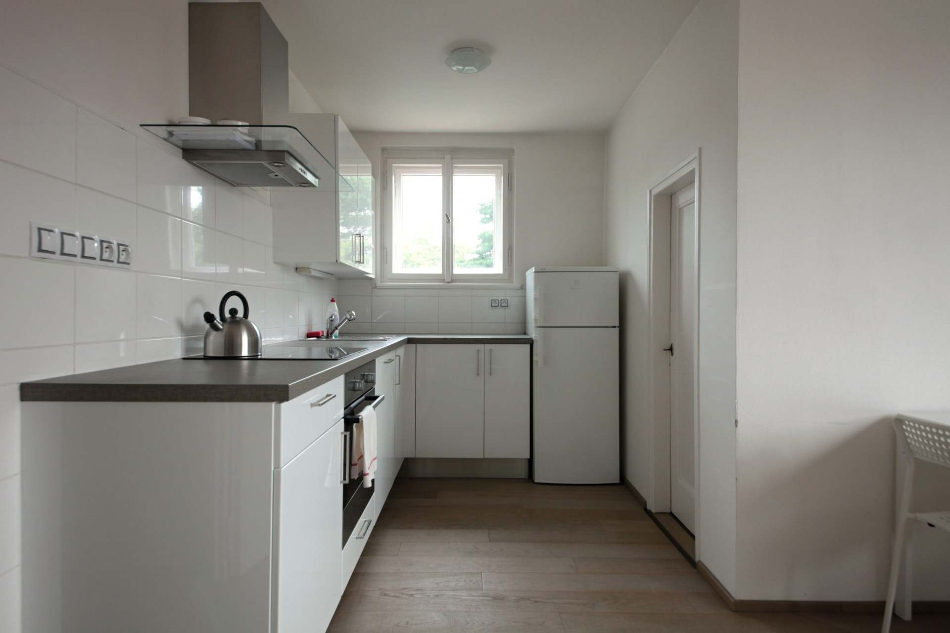 White kitchen with appliances and window