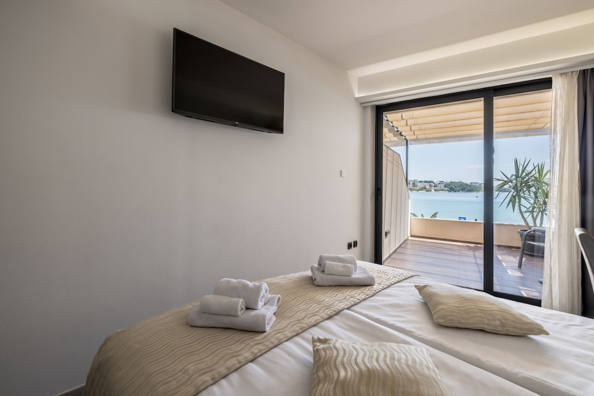 A comfortable bed facing a flat-screen TV.