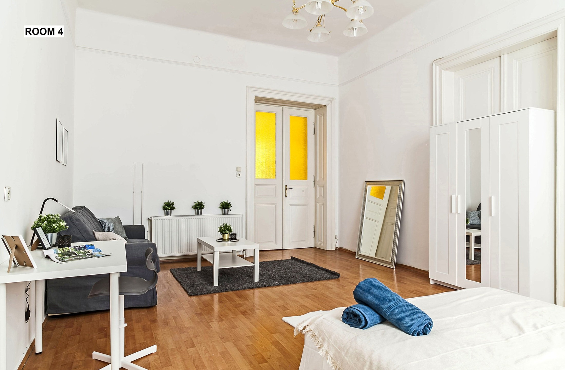 Comfortable double bed next to large windows providing excellent natural daylight.