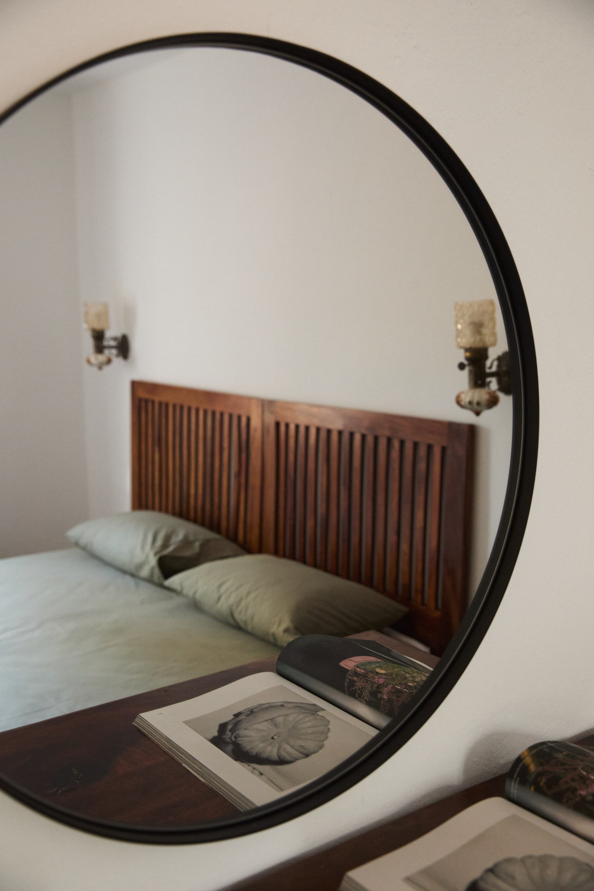 Bedroom reflected in round mirror
