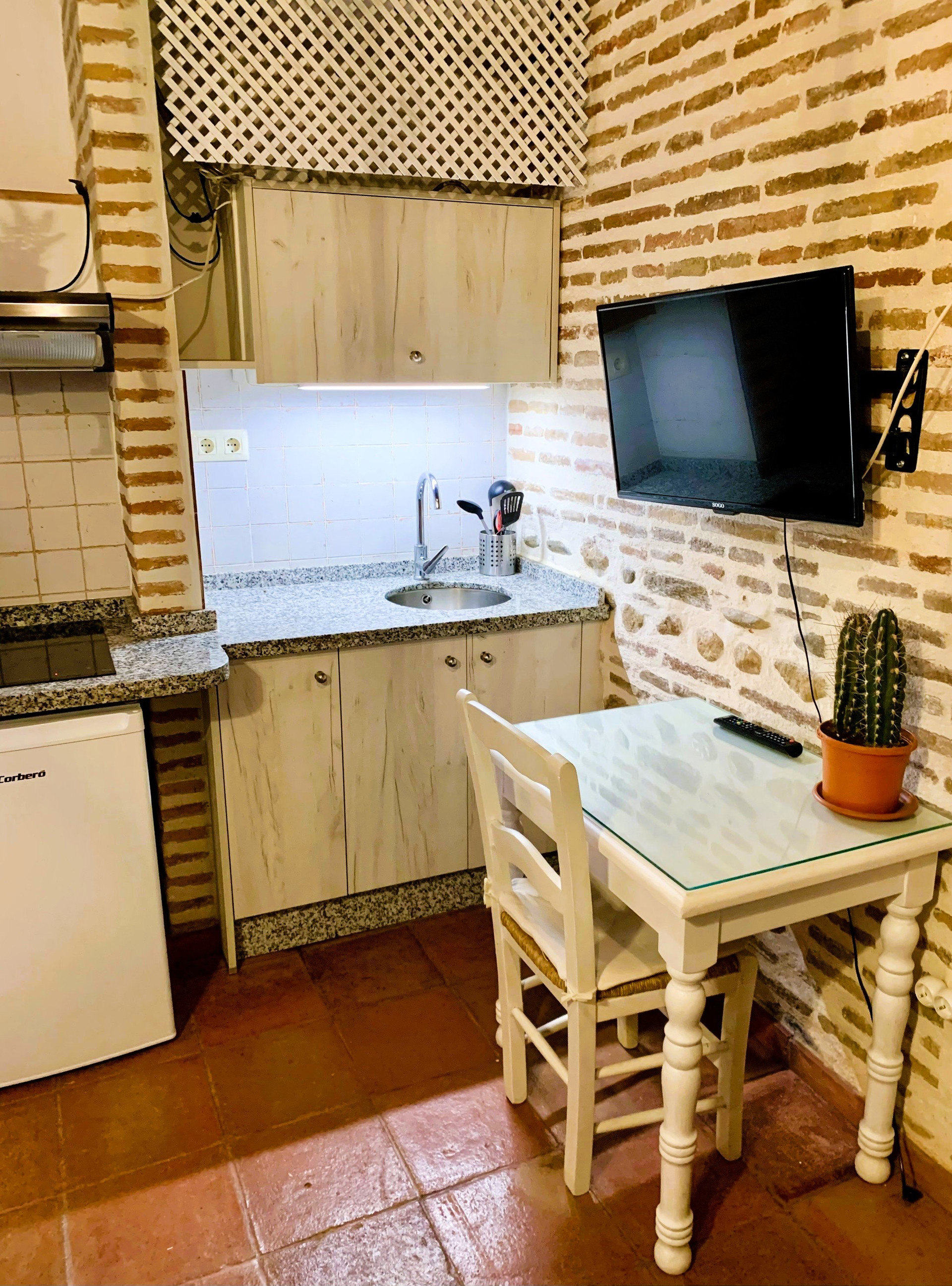 Compact kitchen with brick wall TV