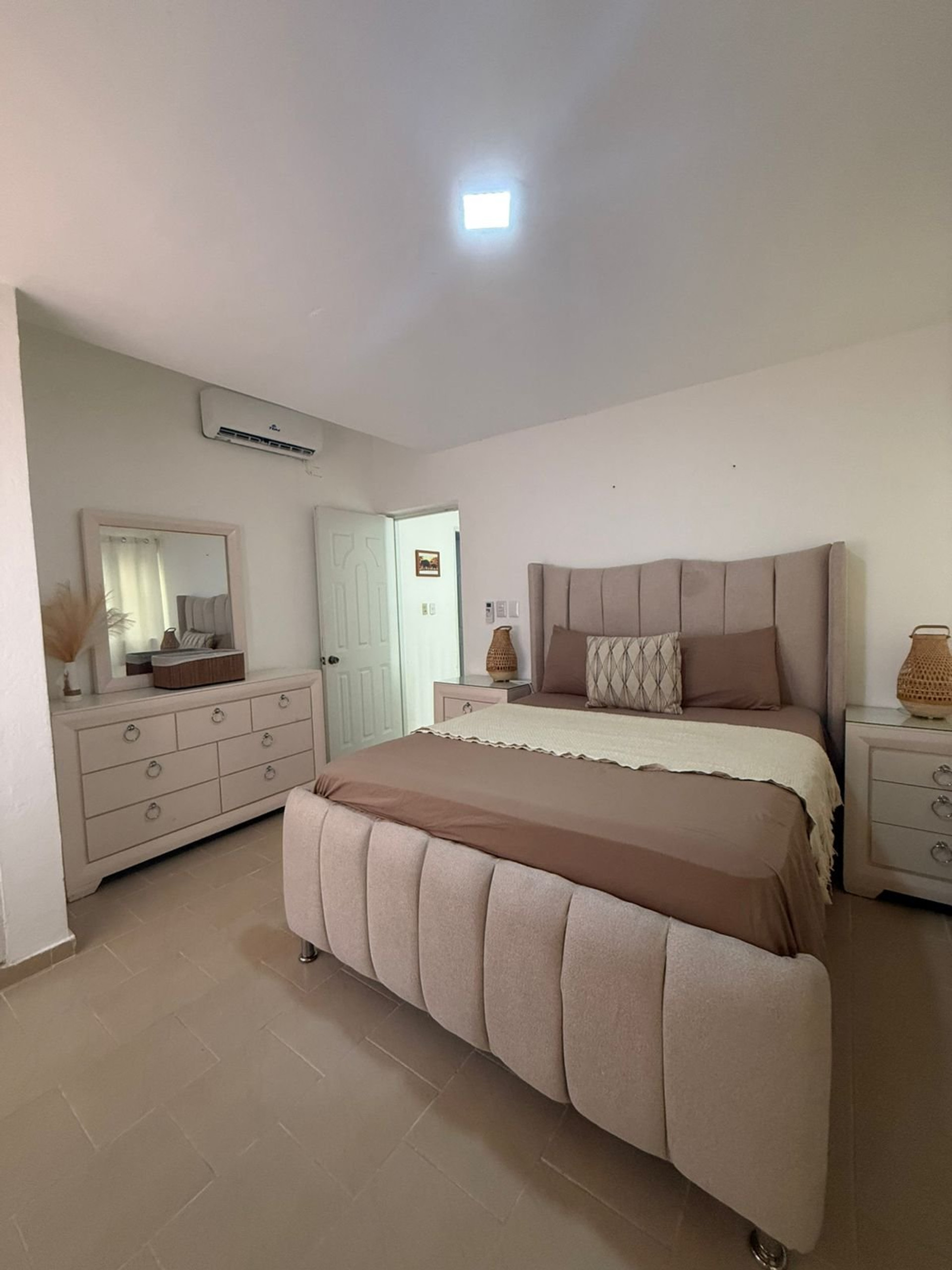 Bedroom with upholstered bed and dresser