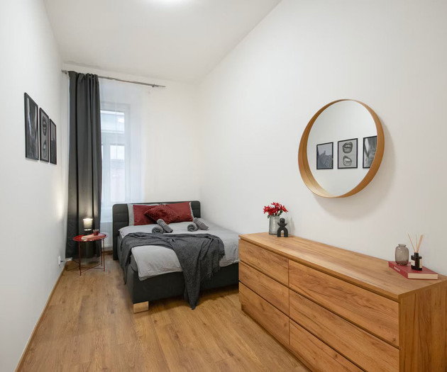 Bedroom with dresser and round mirror