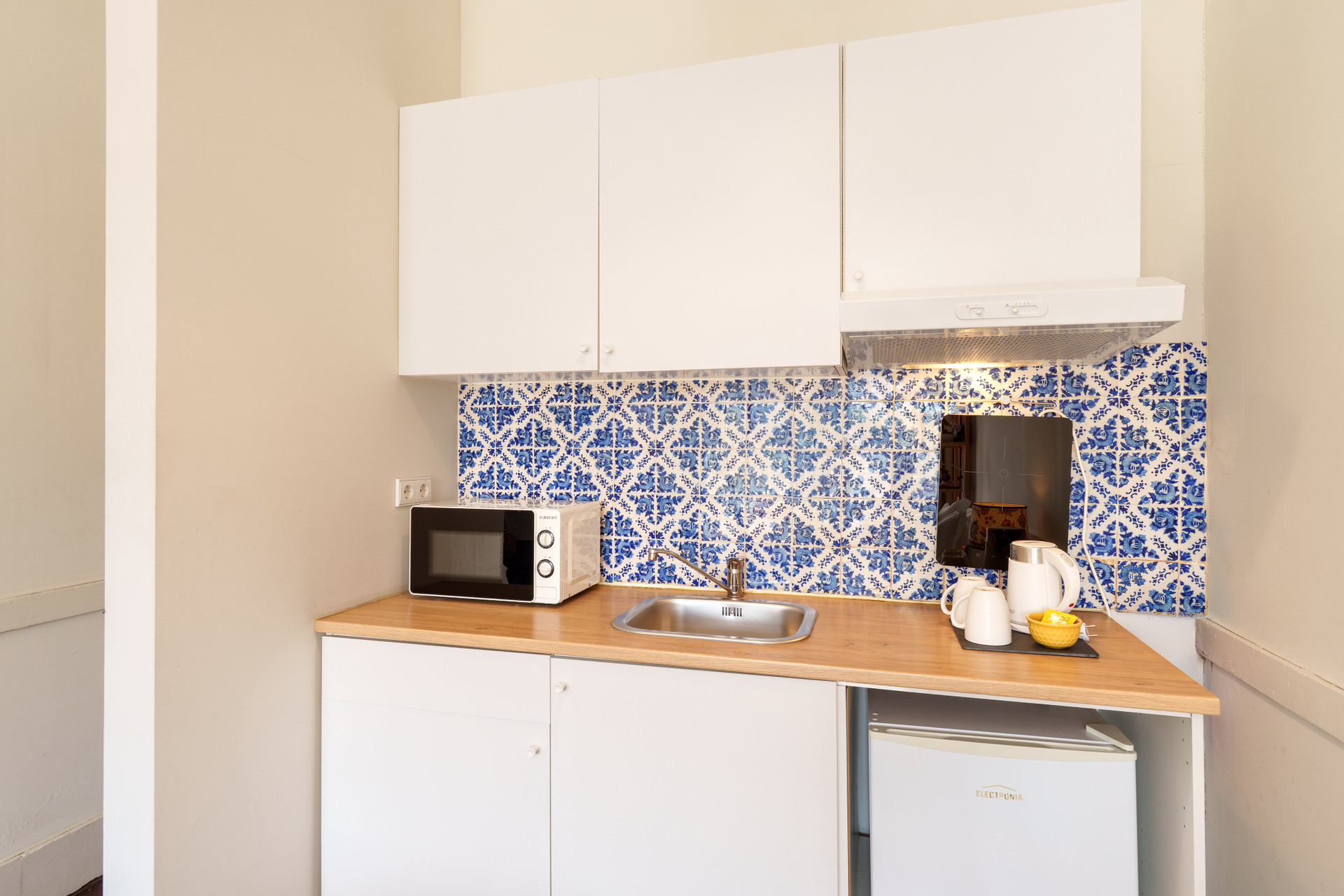 Compact kitchenette with azulejo backsplash