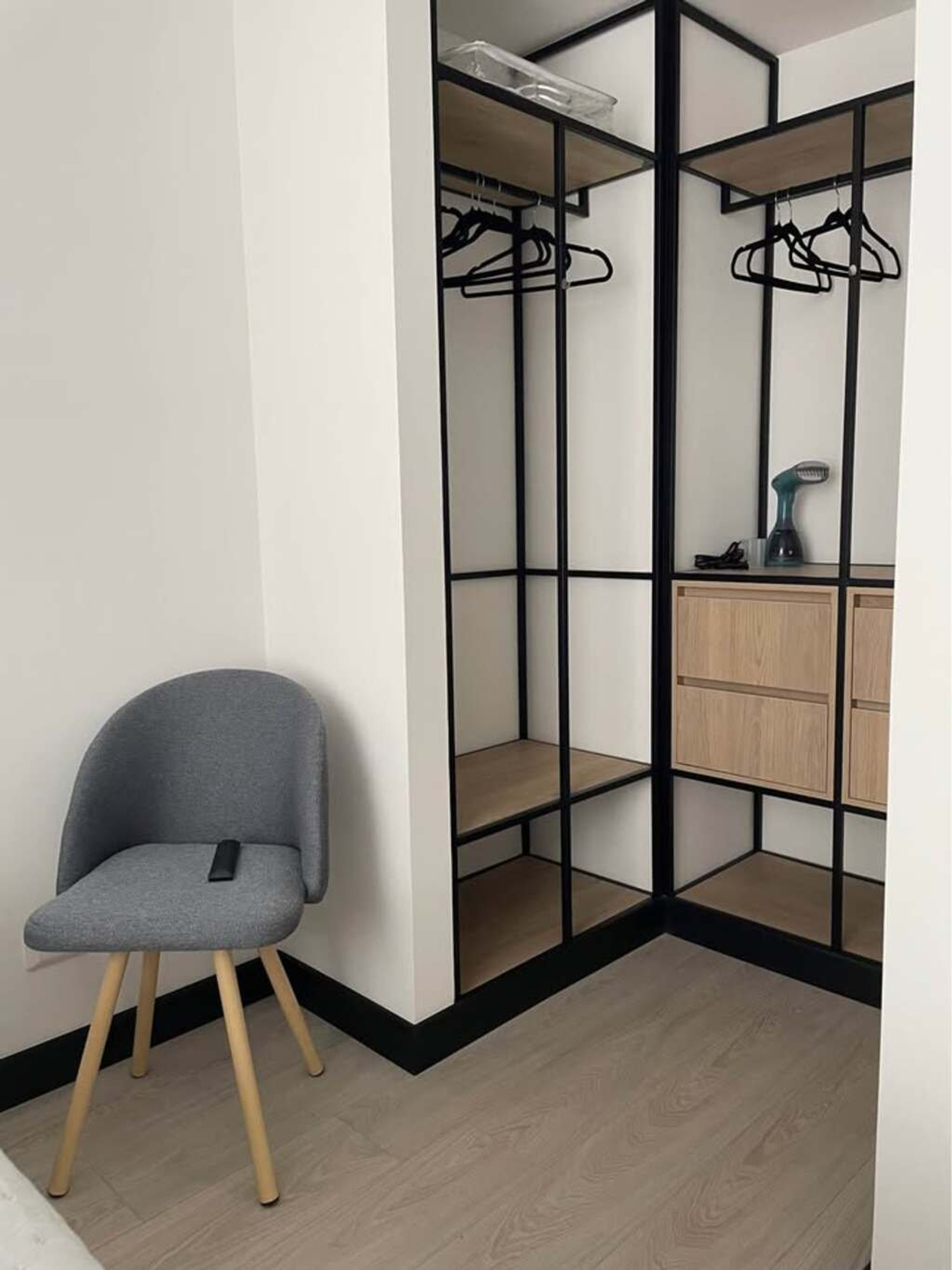 he room includes an open closet with hangers and drawers, offering convenient storage.