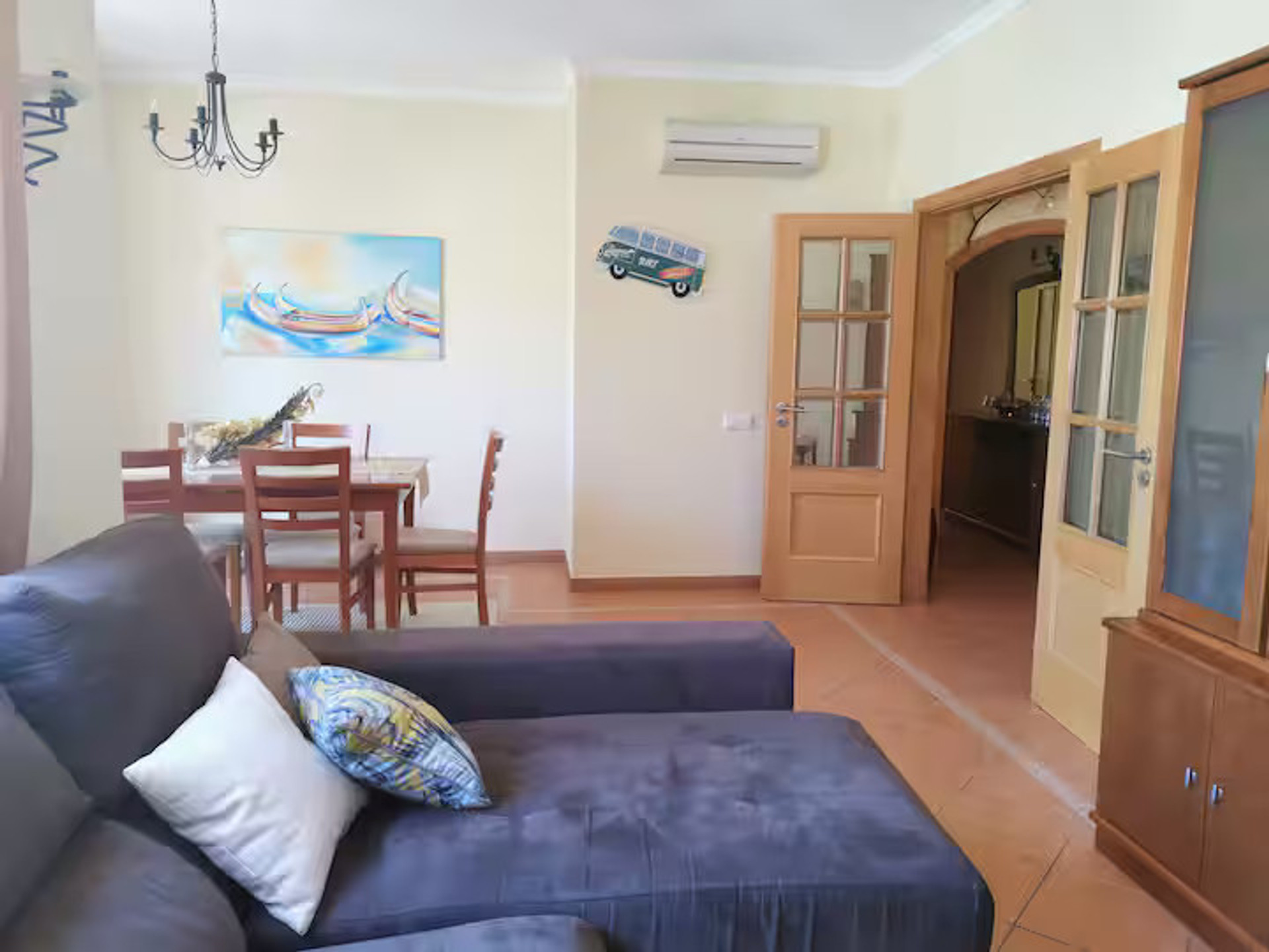 Living room with AC and dining table.
