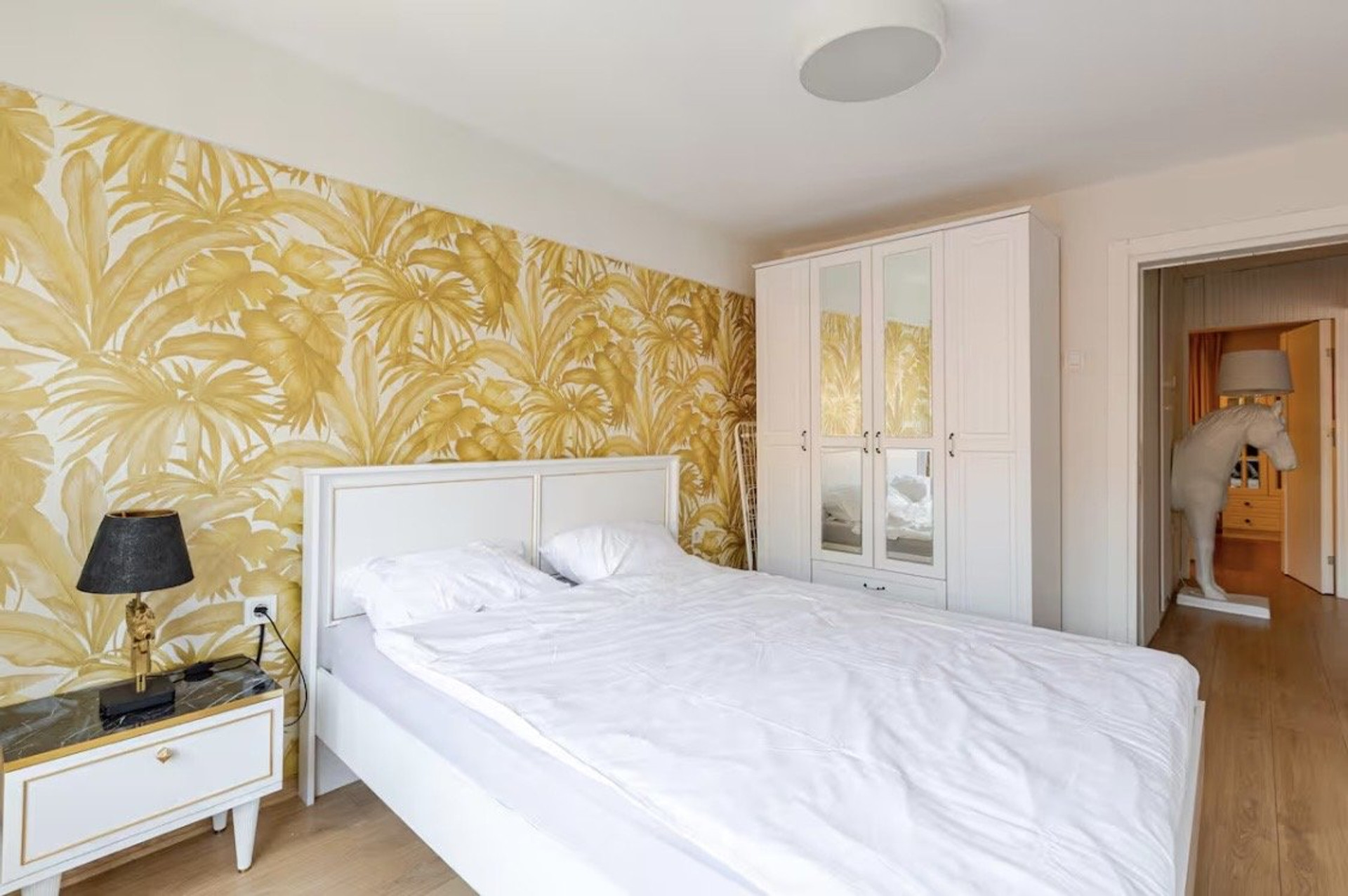 Bedroom with tropical wallpaper and wardrobe