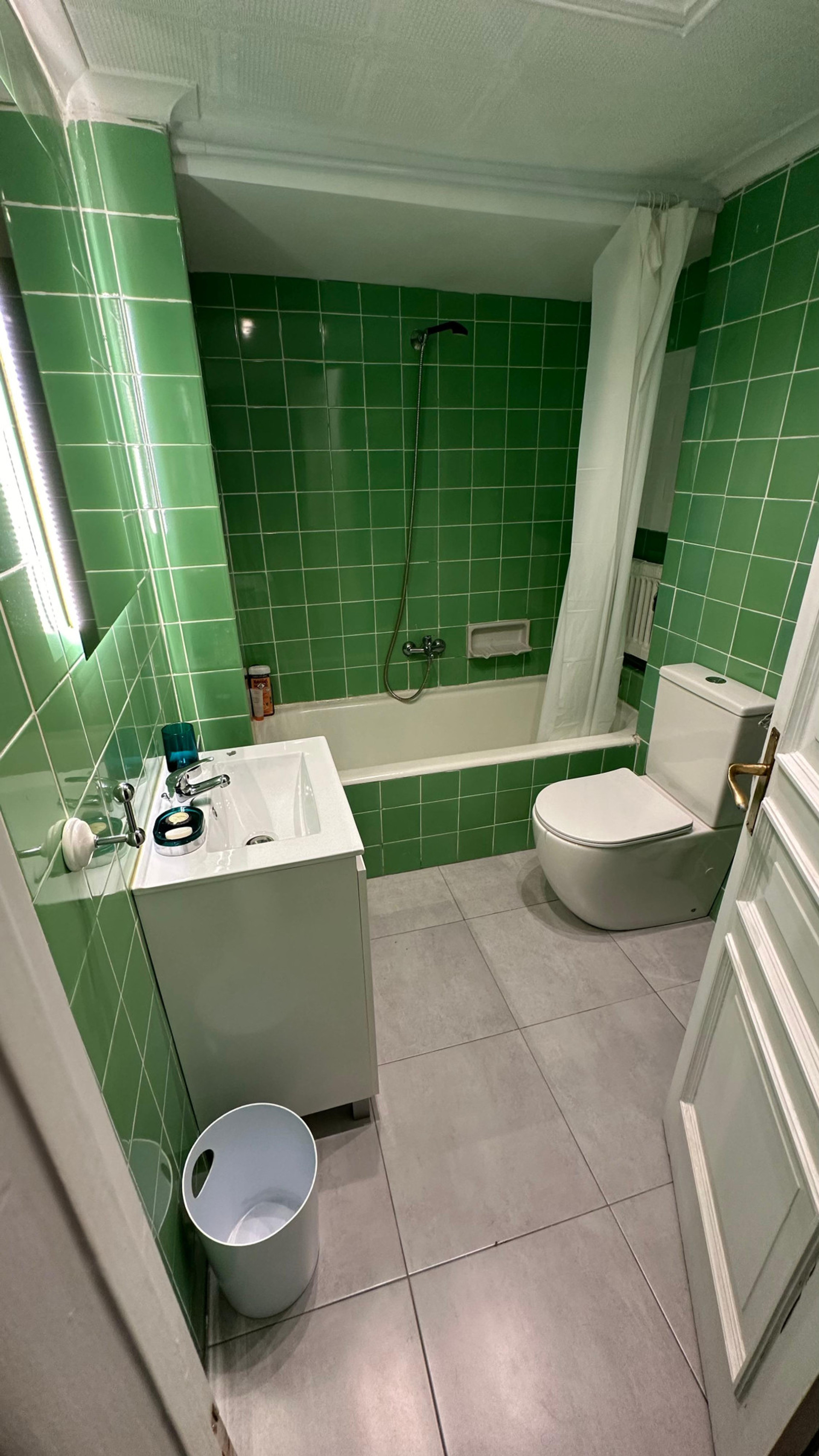 Green tiled bathroom with bathtub