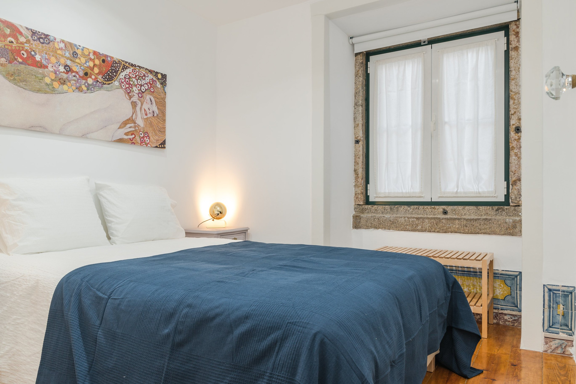Bedroom with blue bedspread and art