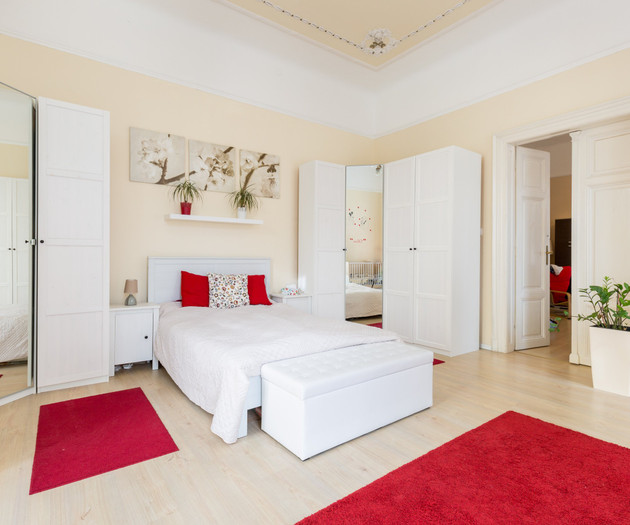 Spacious bedroom with red rugs