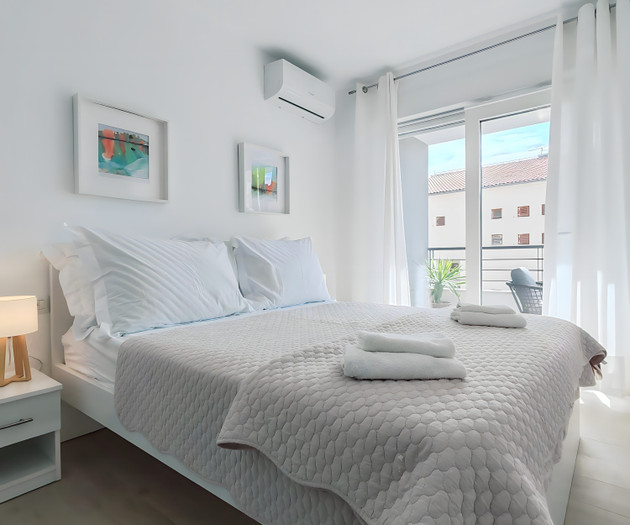 Bedroom with balcony and curtains