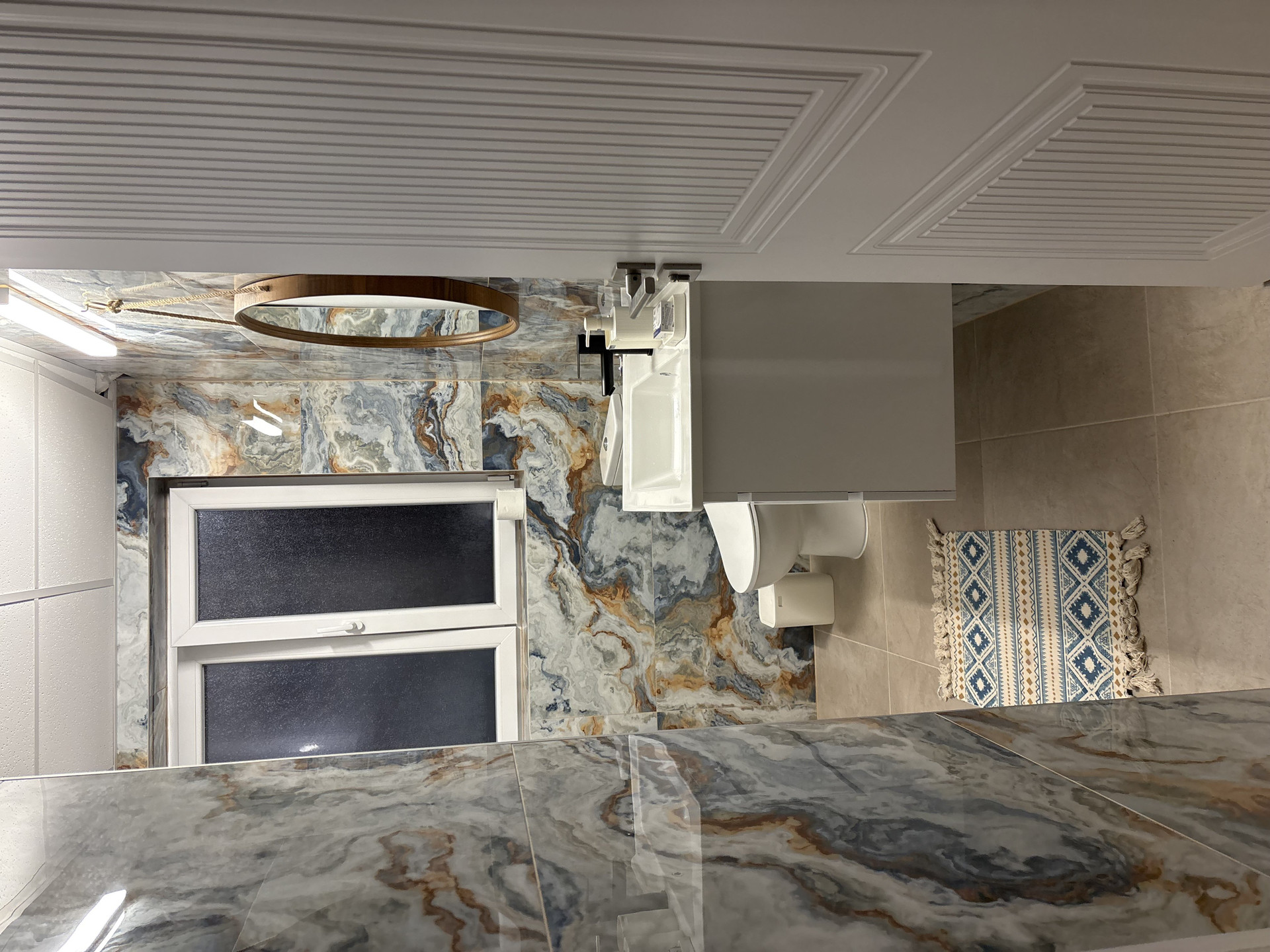 Marble-tiled bathroom with toilet