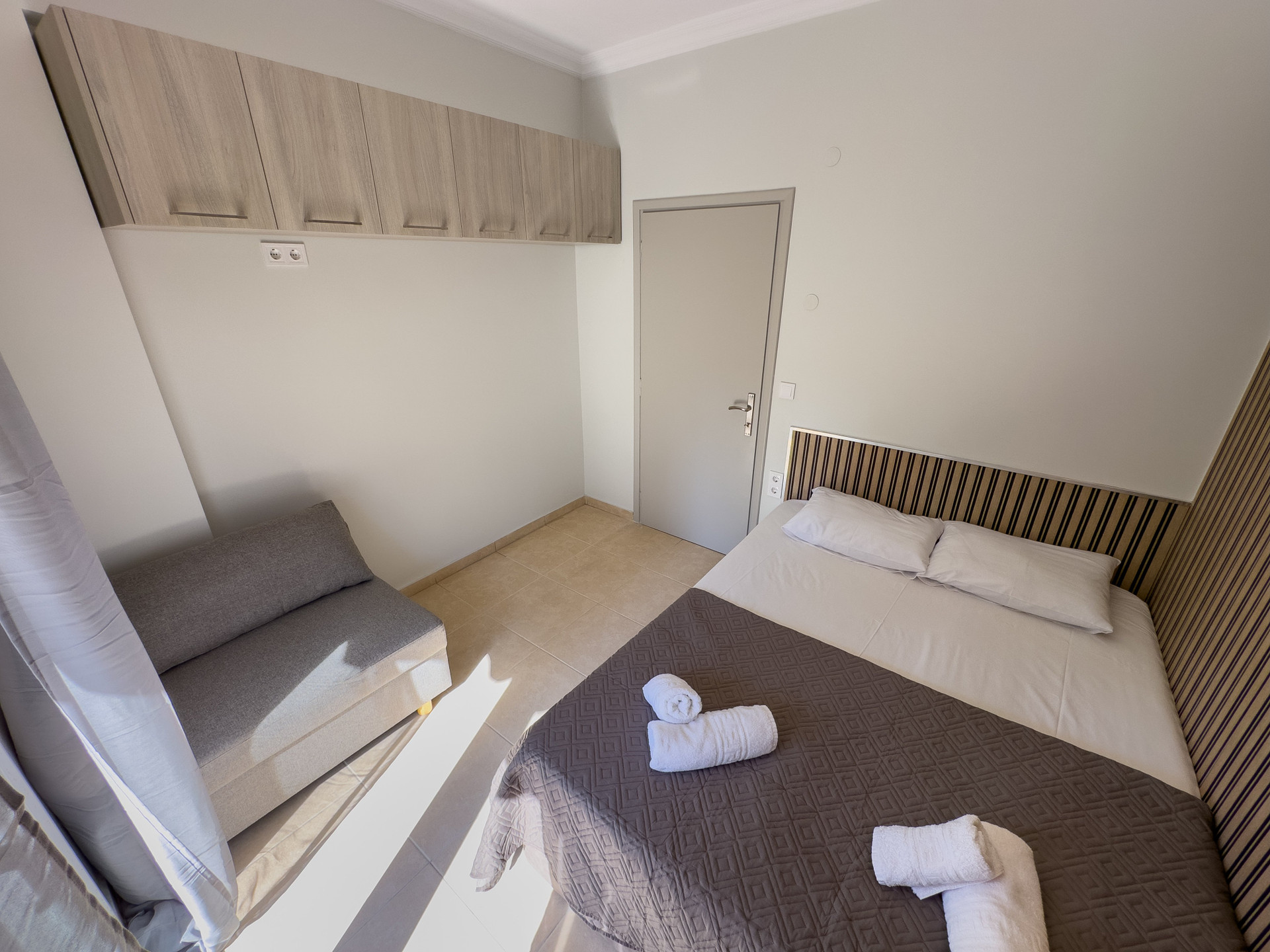 Bedroom with sofa and overhead storage