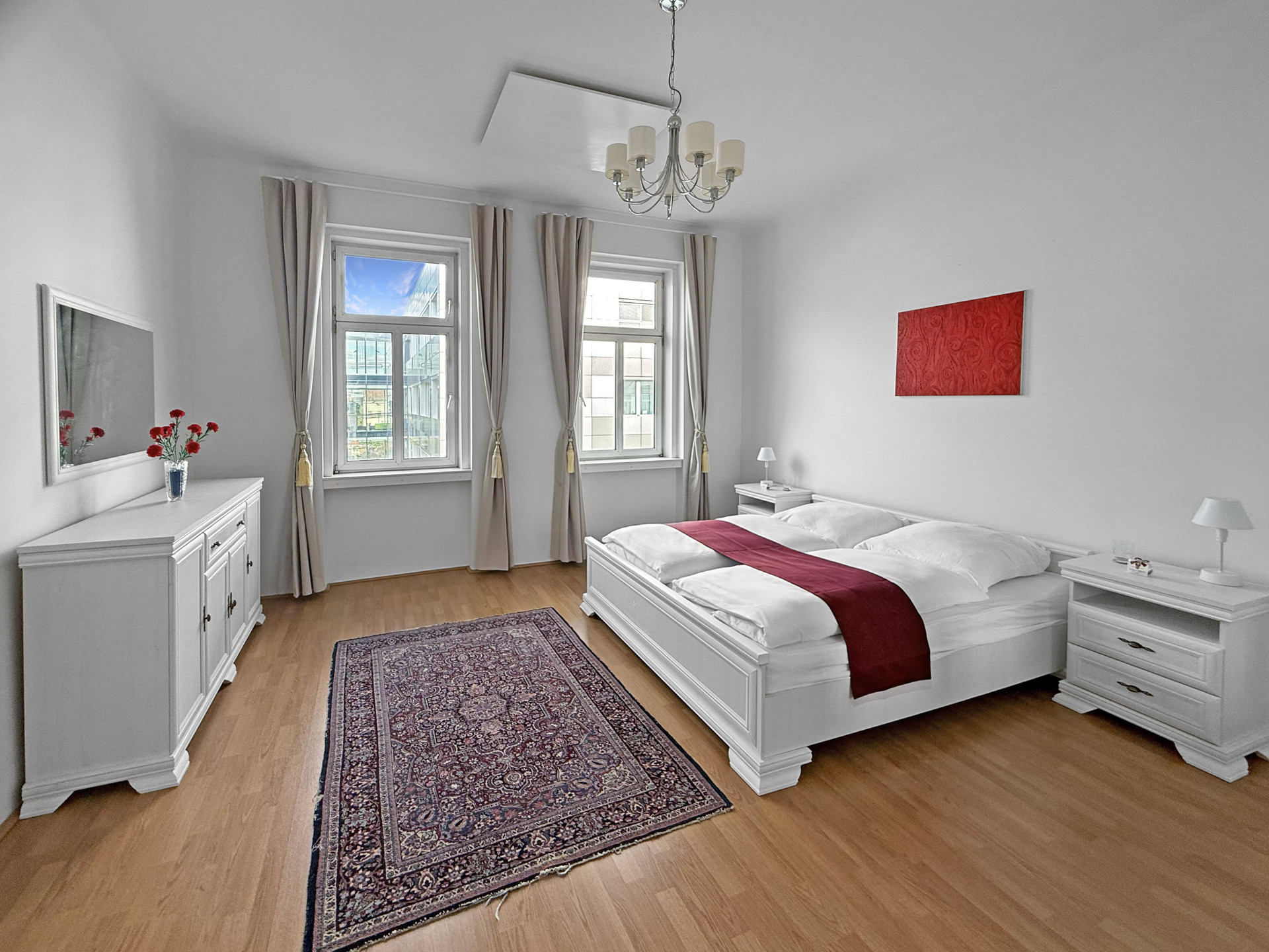 Spacious bedroom with red artwork