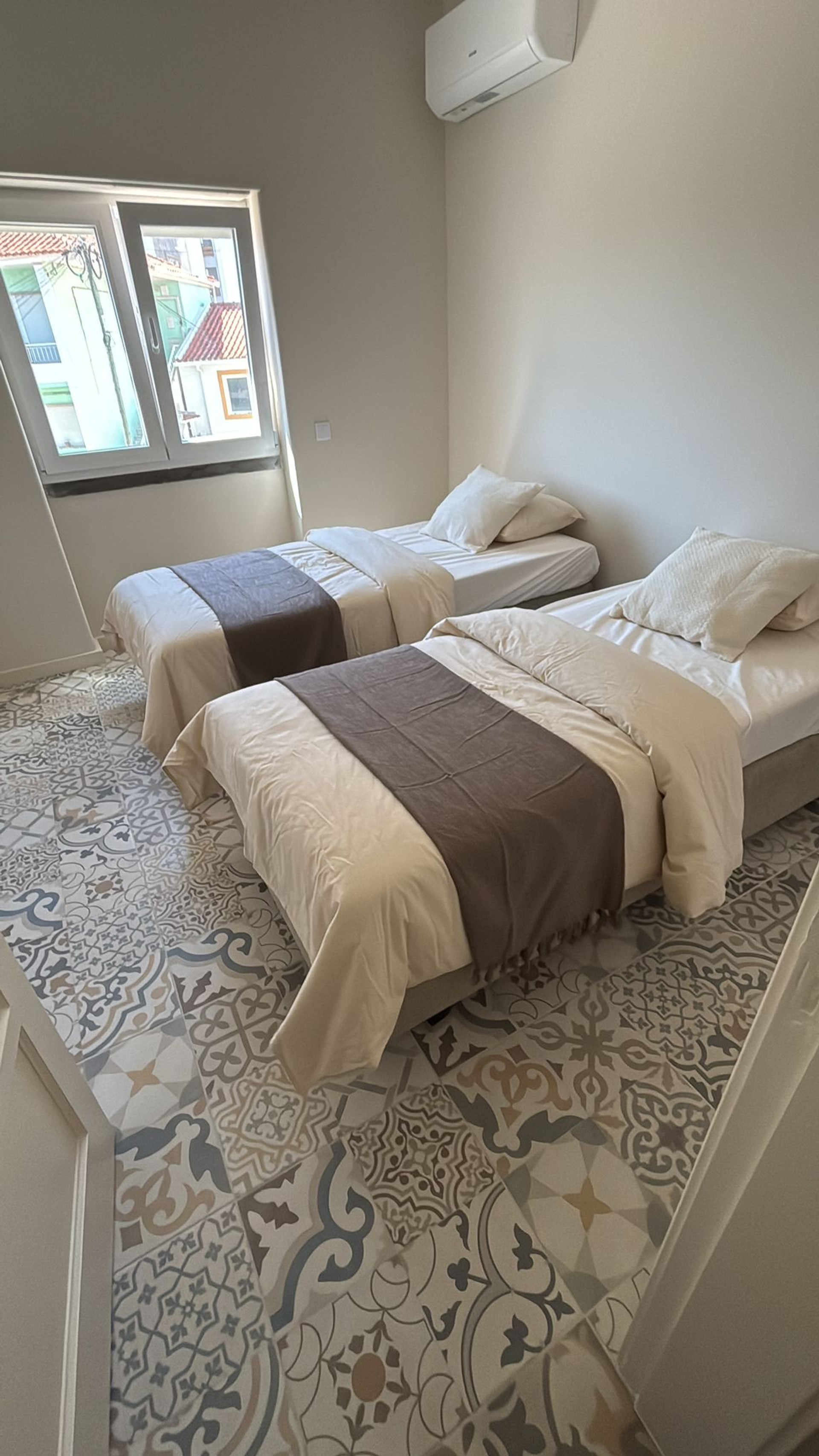 Twin bedroom with patterned tile floor