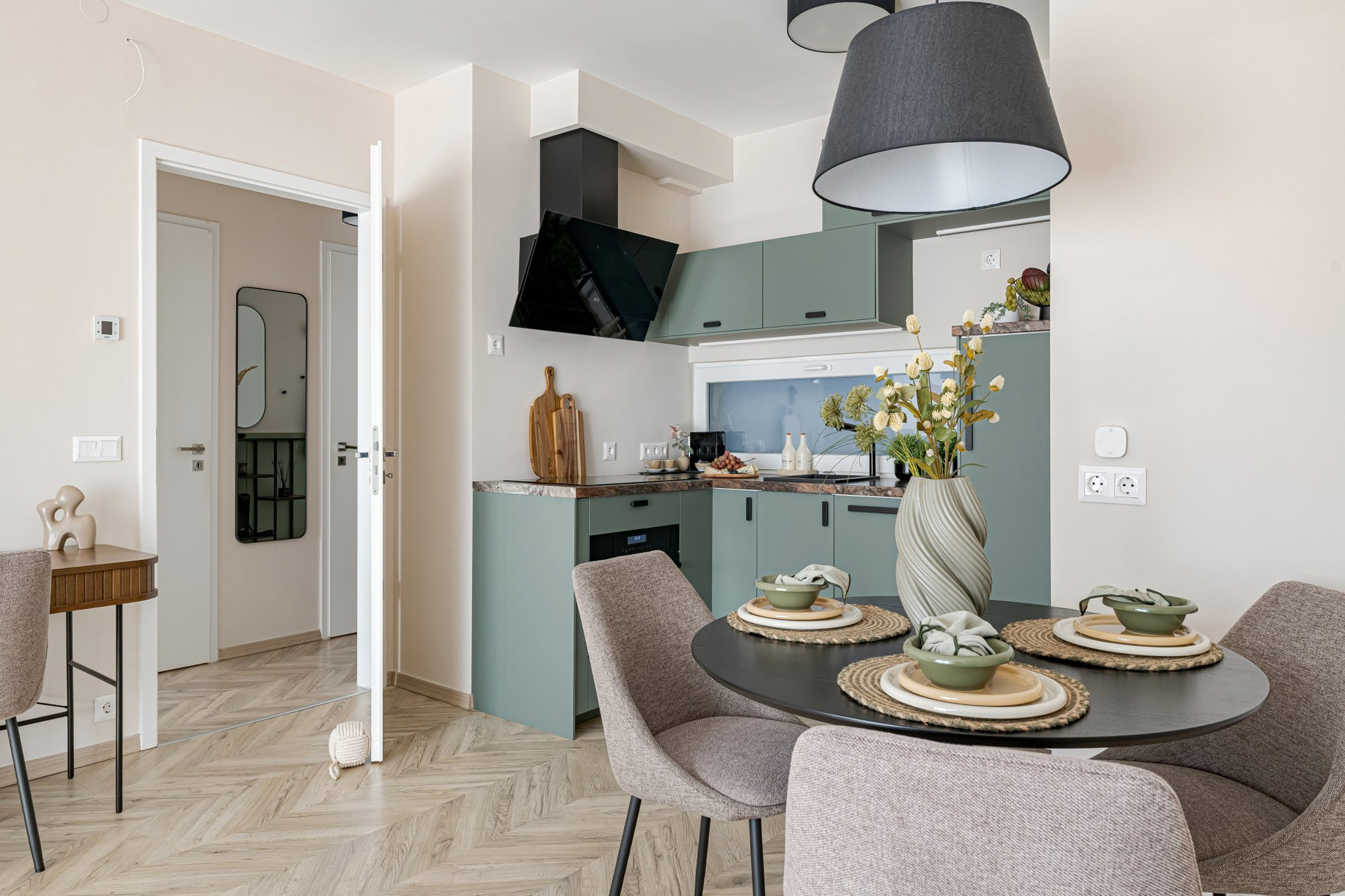 Dining table beside green kitchen