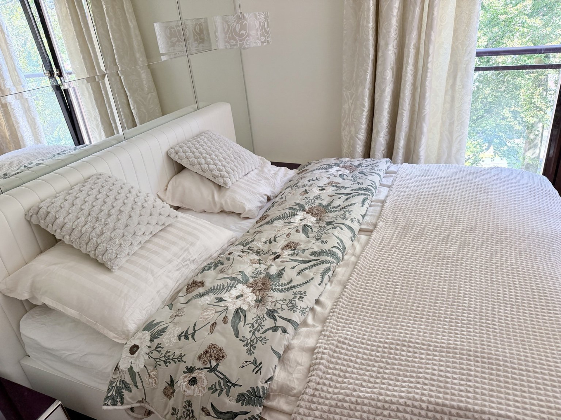 Bedroom with floral bedding and balcony