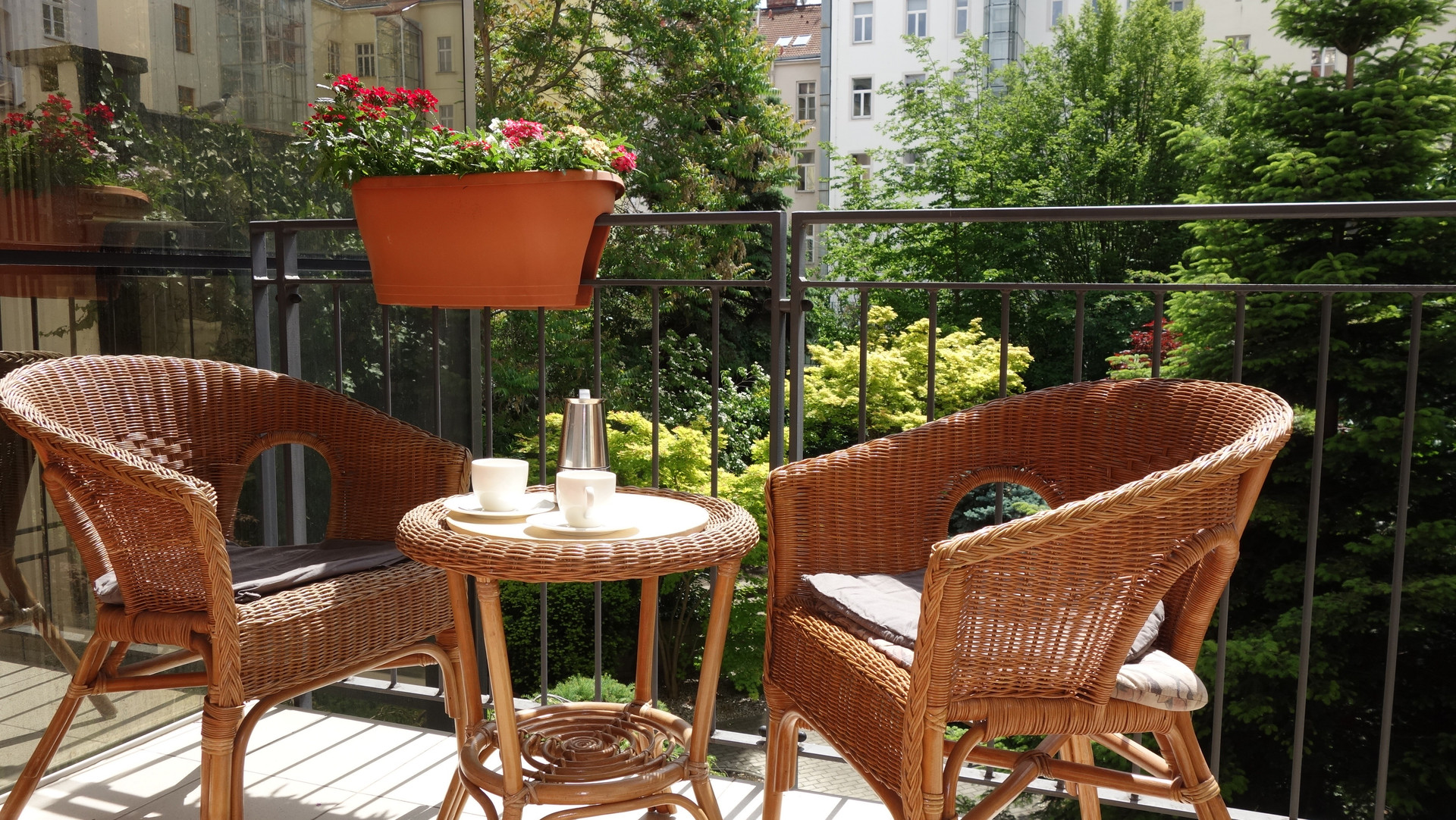 The terrace is furnished with rattan chairs, a coffee table. 