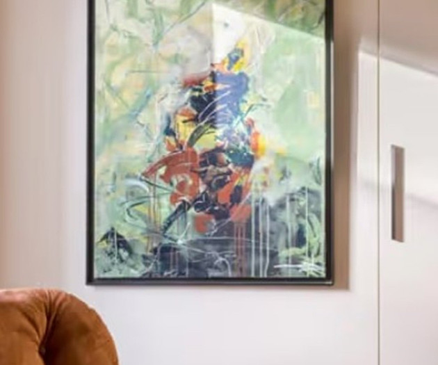Abstract painting beside armchair