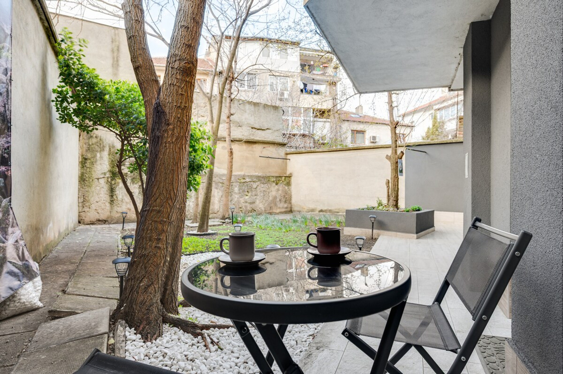 Start your morning with coffee in a quiet garden nook — peaceful, private, and shaded by trees.