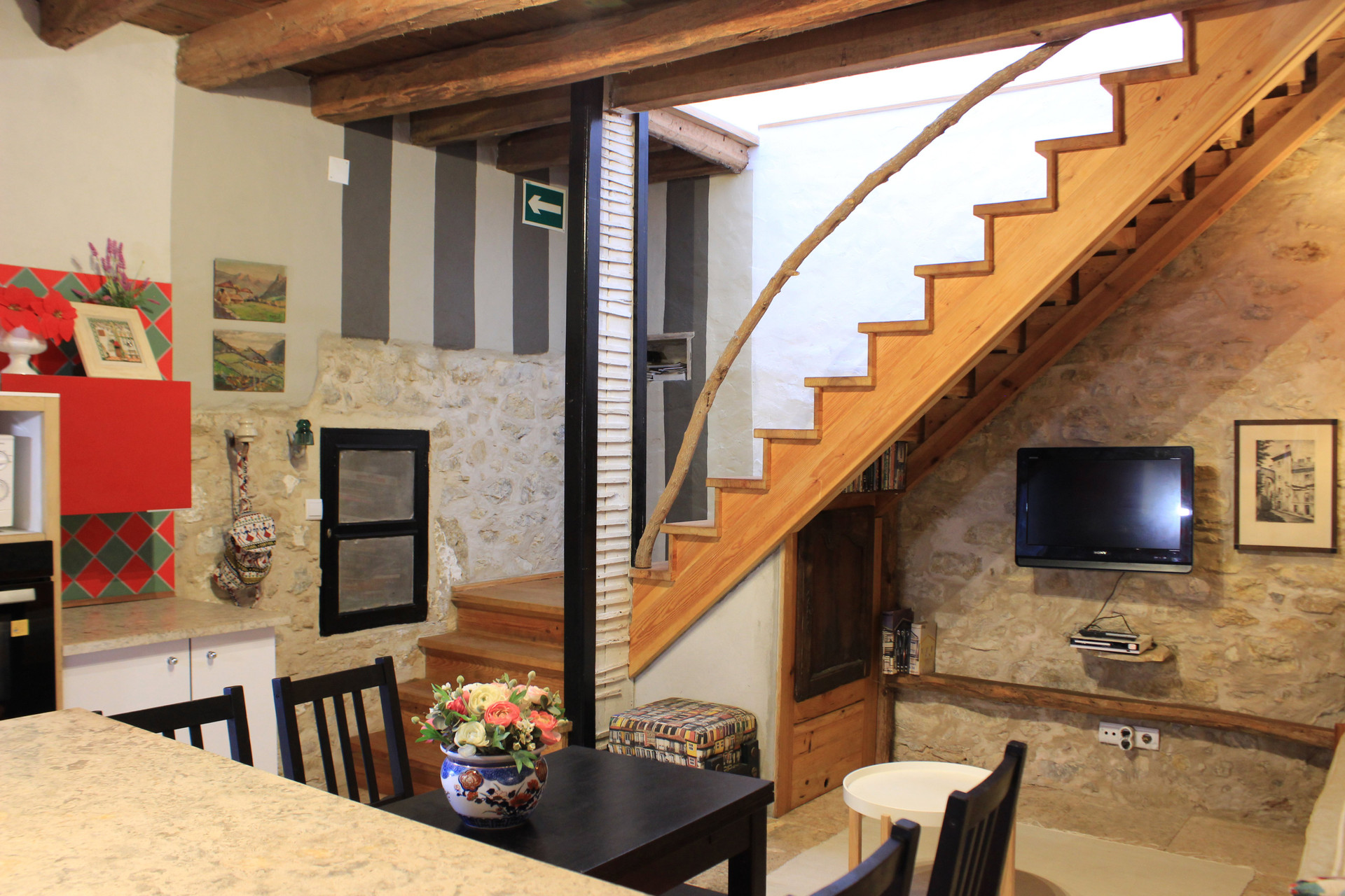 Open living area with wooden staircase TV