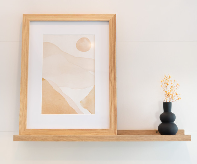 Framed art on wooden shelf
