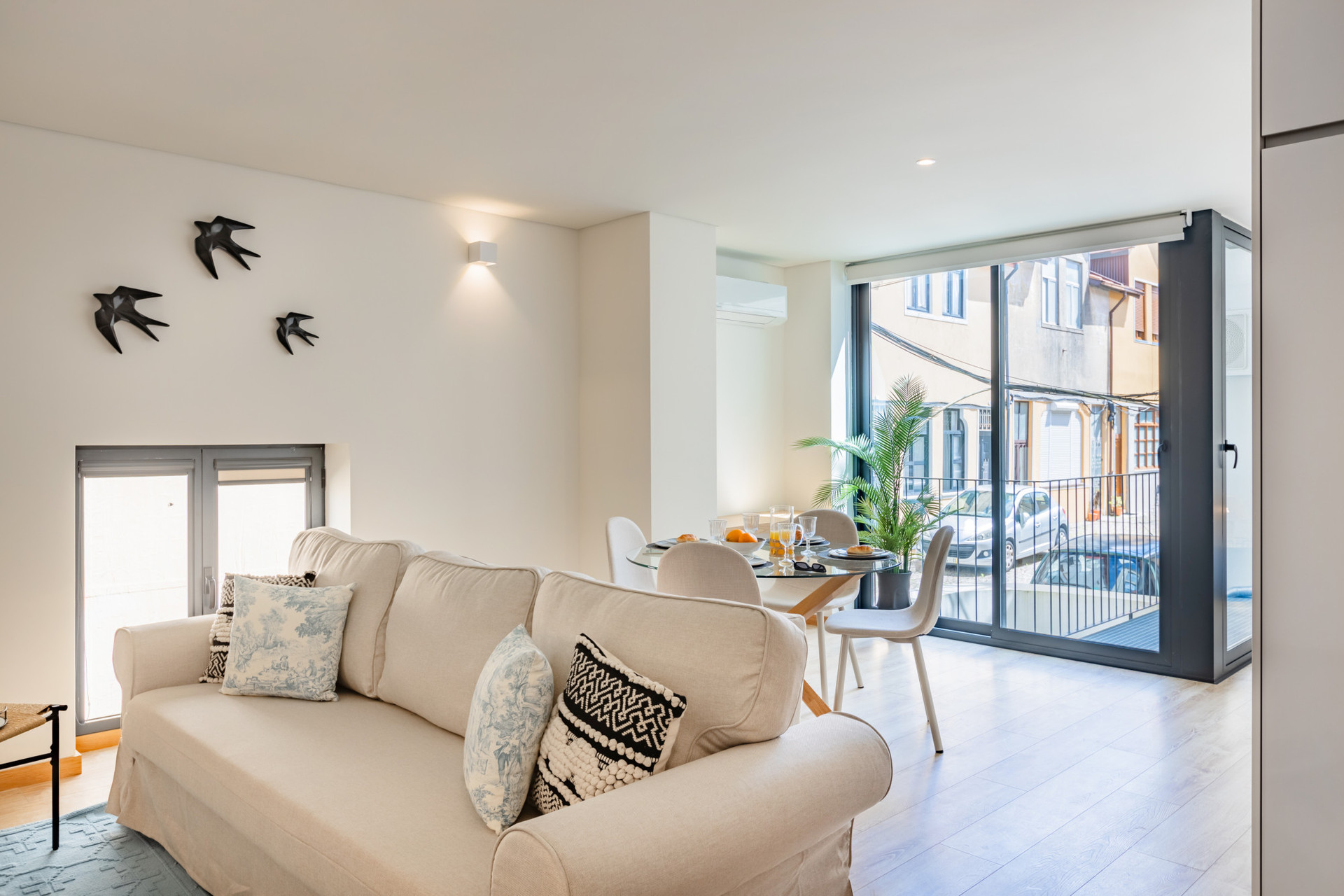 Living area with sofa, TV and AC. Dining table for 4. The full length french windows flood the space with light!