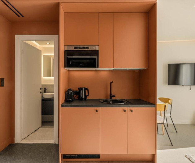 Orange kitchenette with modern appliances