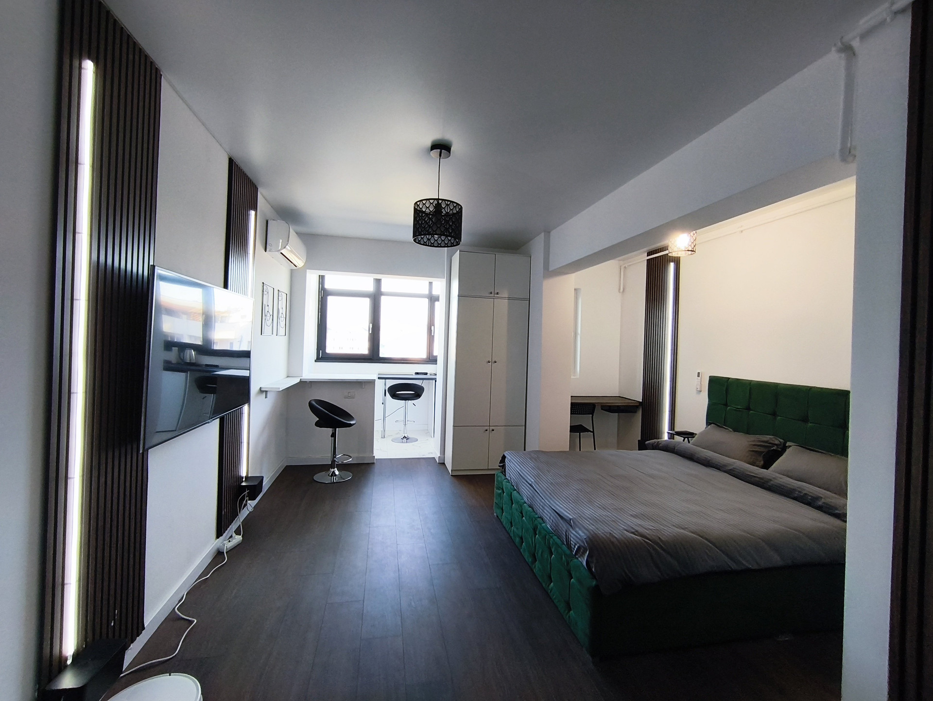 Bedroom with green bed and kitchenette