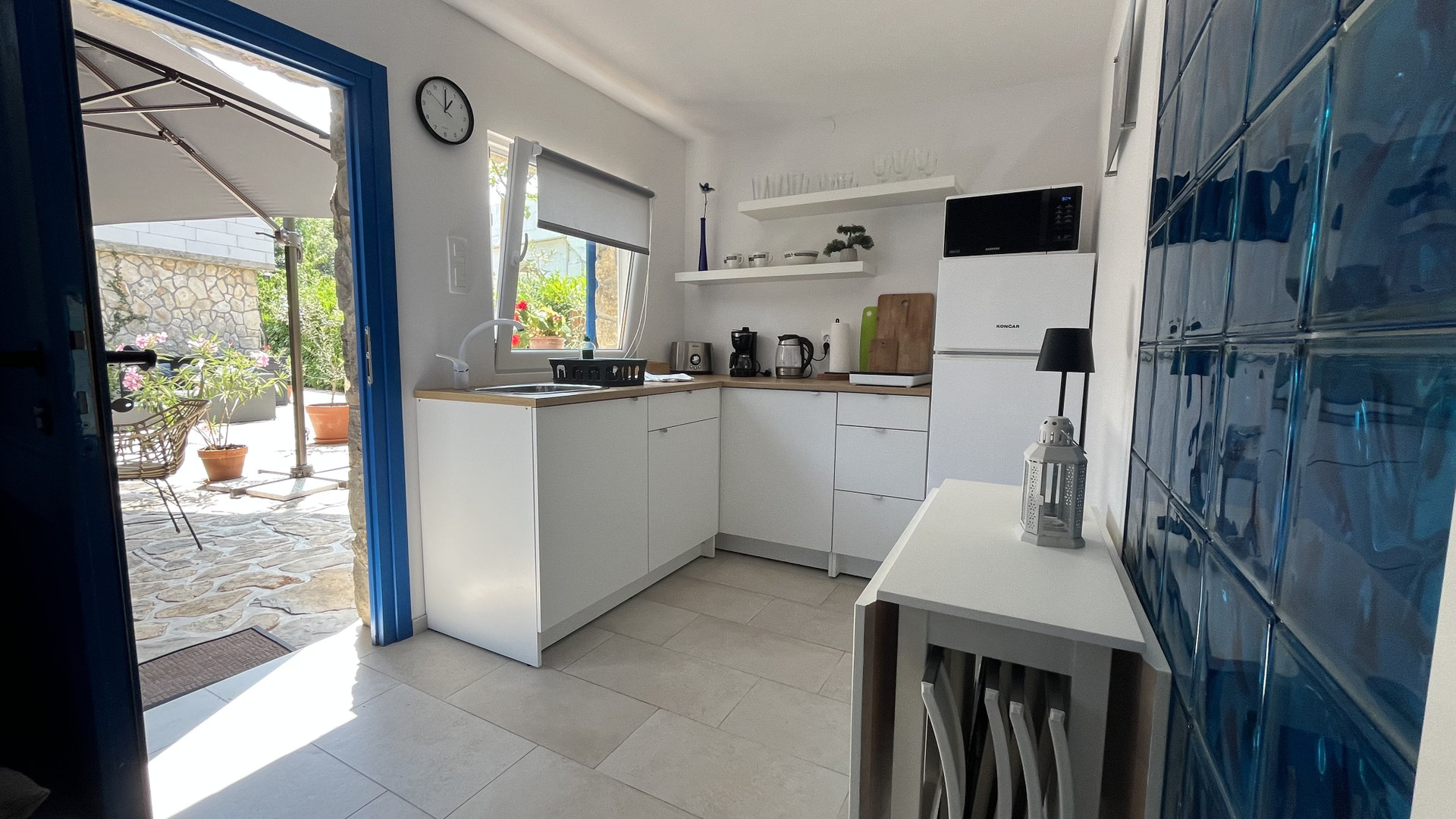 Compact white kitchen with patio access