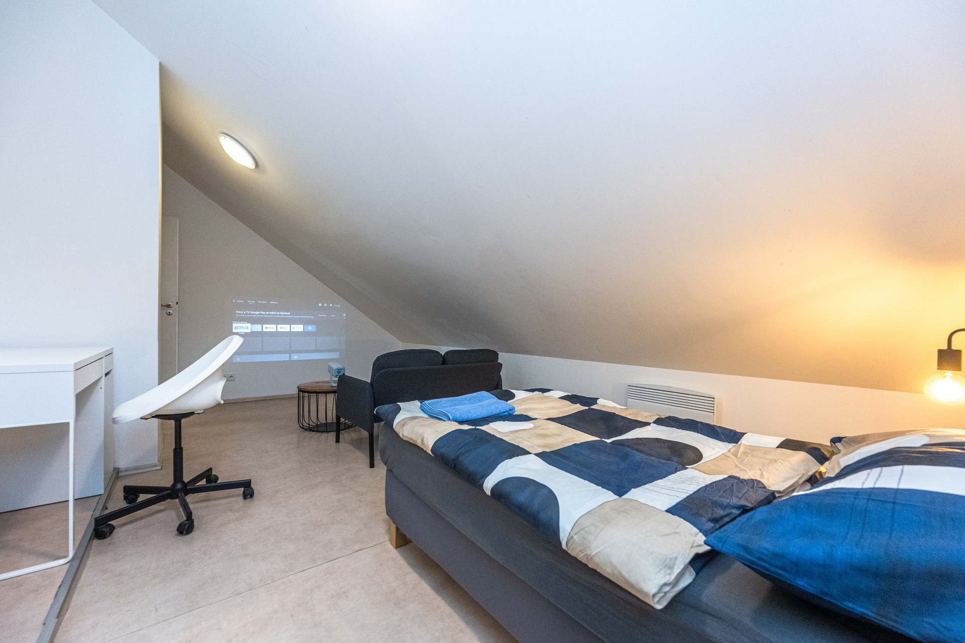 Attic bedroom with desk and bed