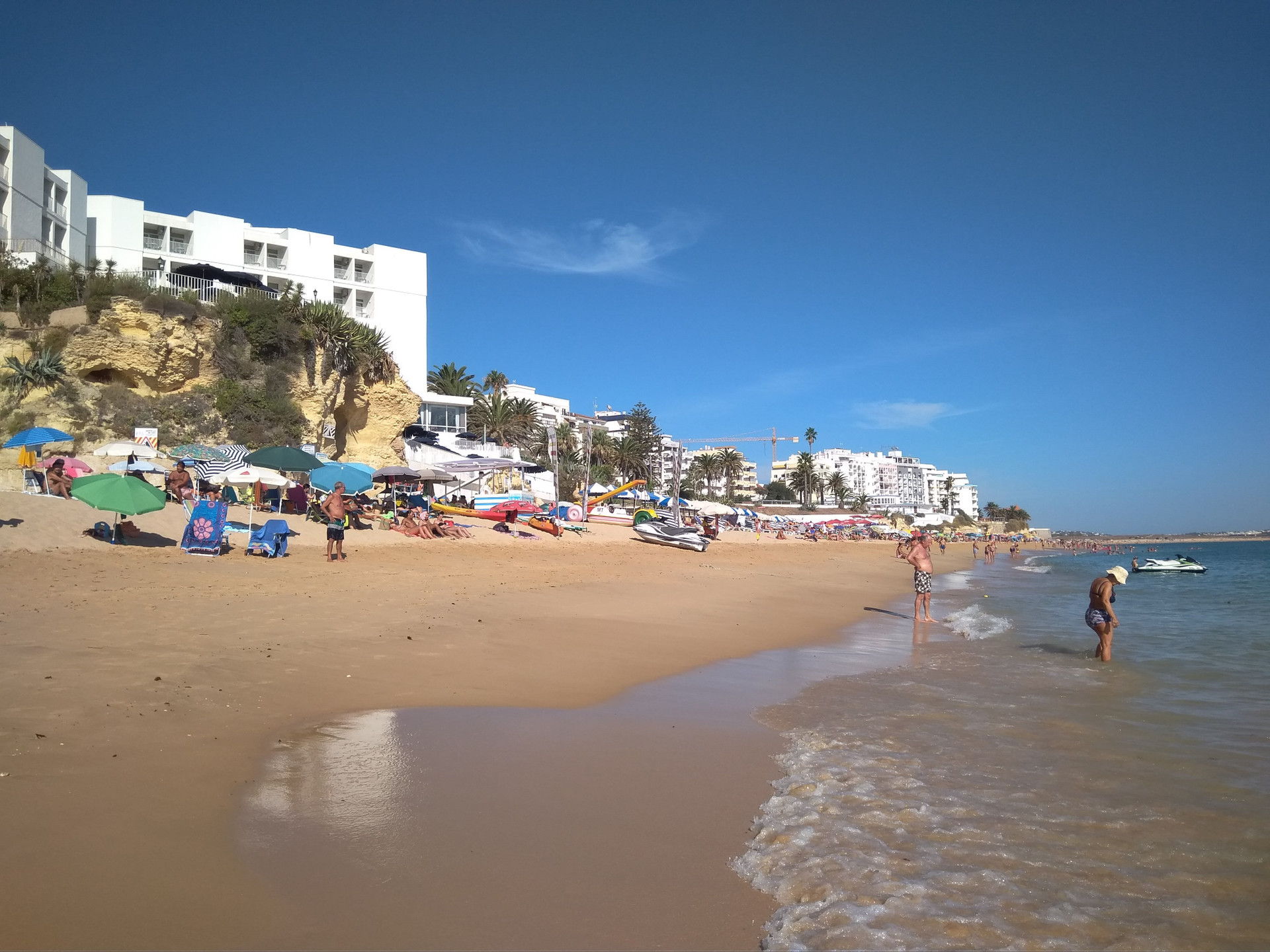 Sunny beach with umbrellas and buildings