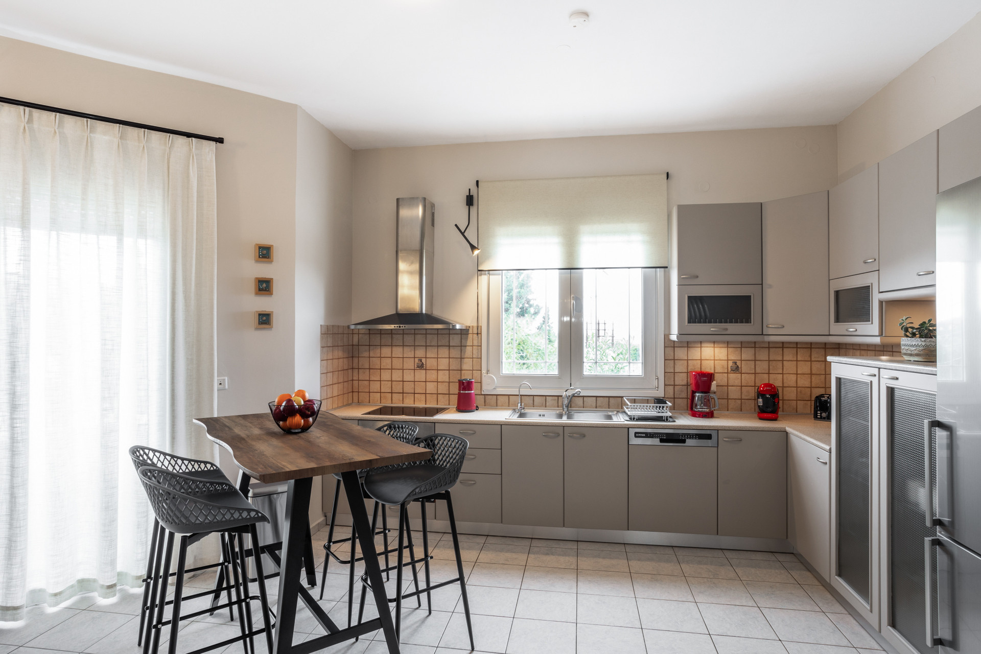 Modern kitchen with breakfast bar, bar stools, and premium appliances for convenient meal preparation