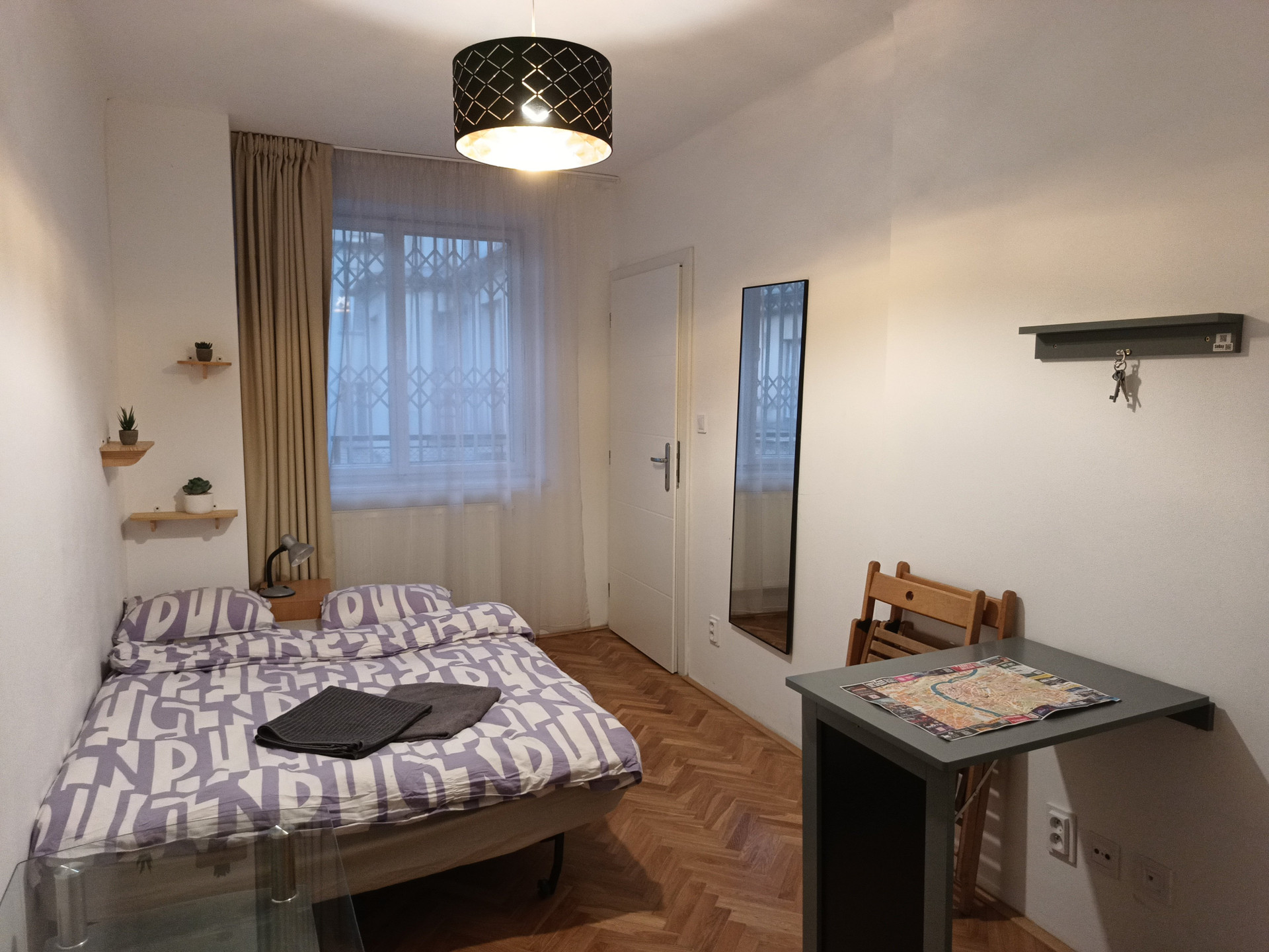 This is how it looks when you walk in to the apartment. Double bed, table with chairs, mirror, glass table and a single sofa chair (not shown). The door on the right leads to the kitchen.