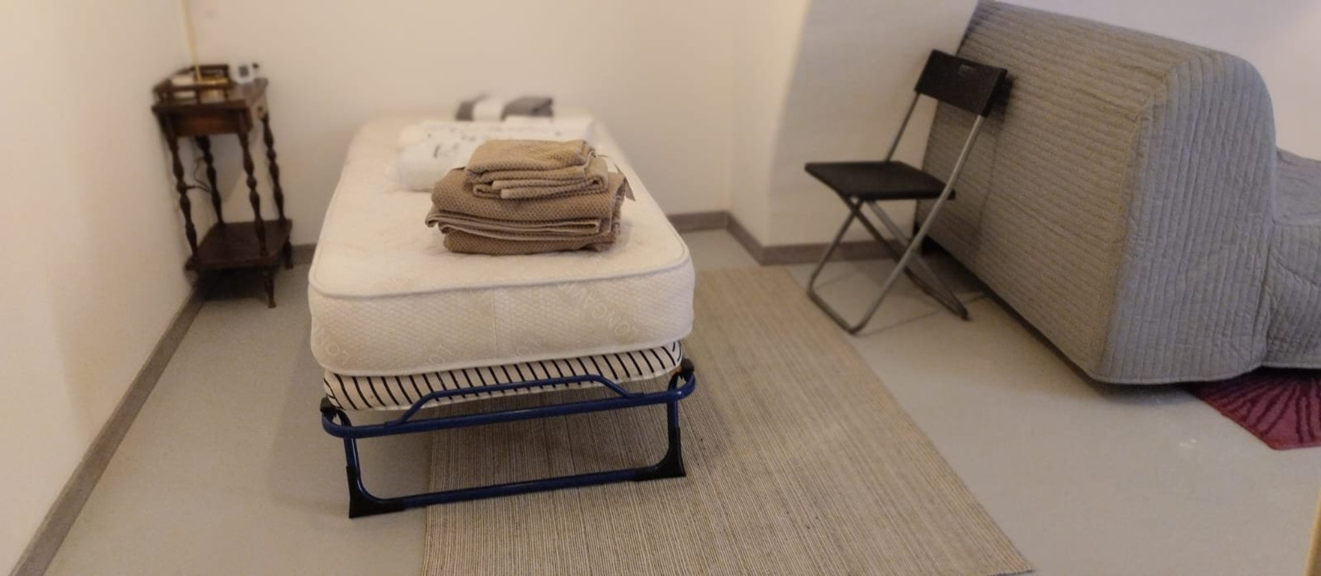 Single bed with sofa in room