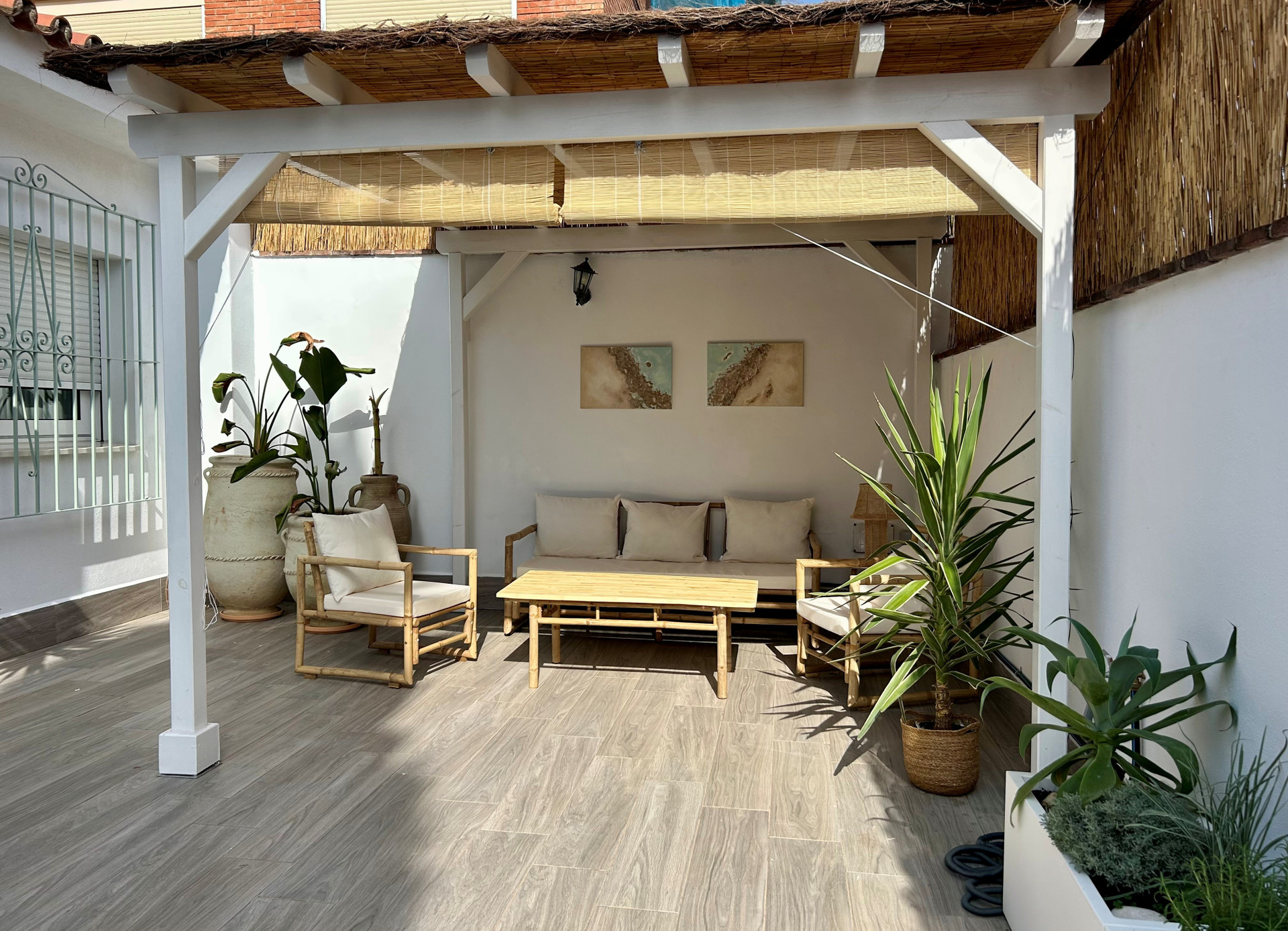 Zona chill out bajo pérgola de madera. 