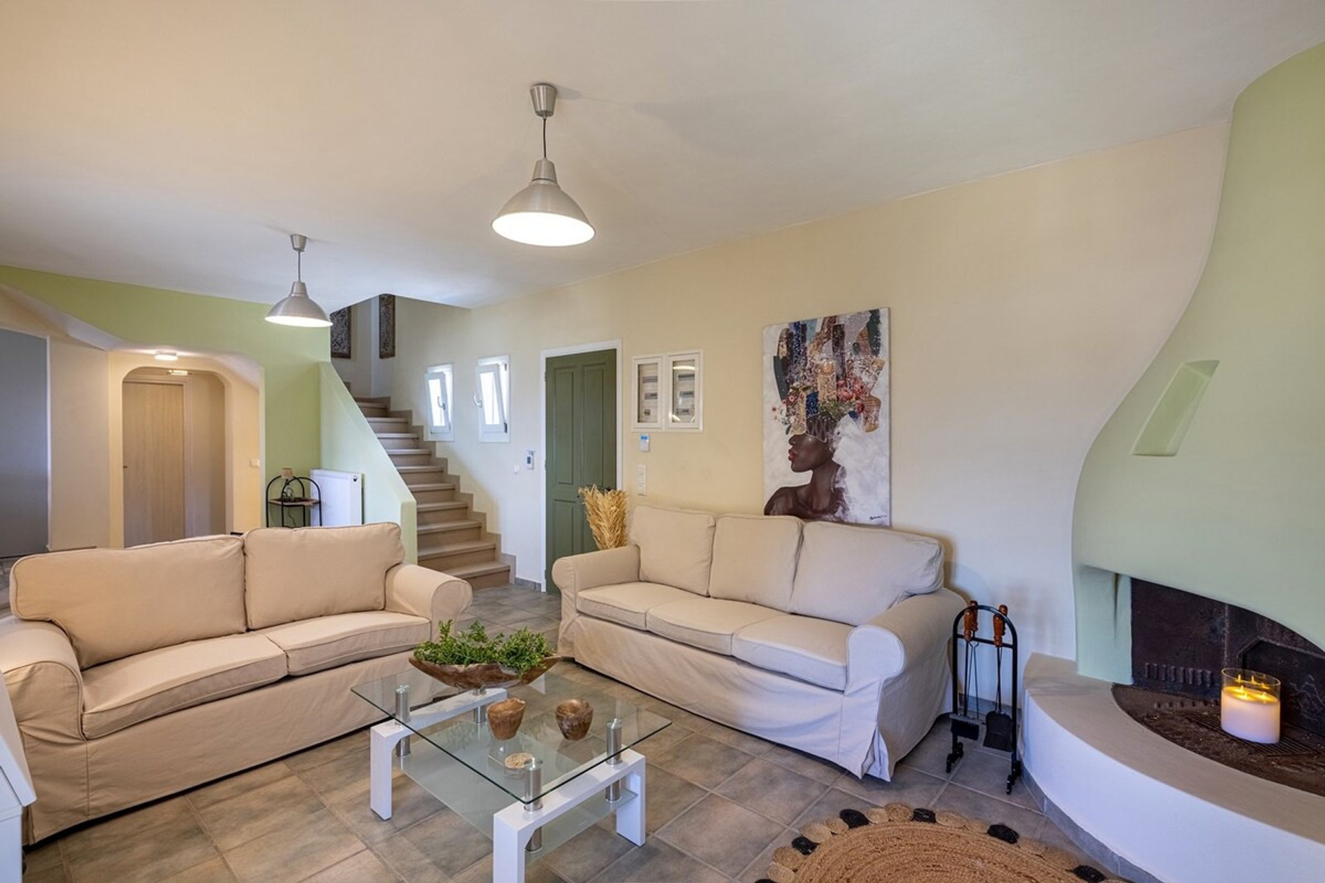 Nestled within this exquisite retreat, discover a living space where soft mint accents complement pristine white walls. The distinctive curved fireplace adds architectural intrigue, while plush sofas invite leisurely relaxation.
