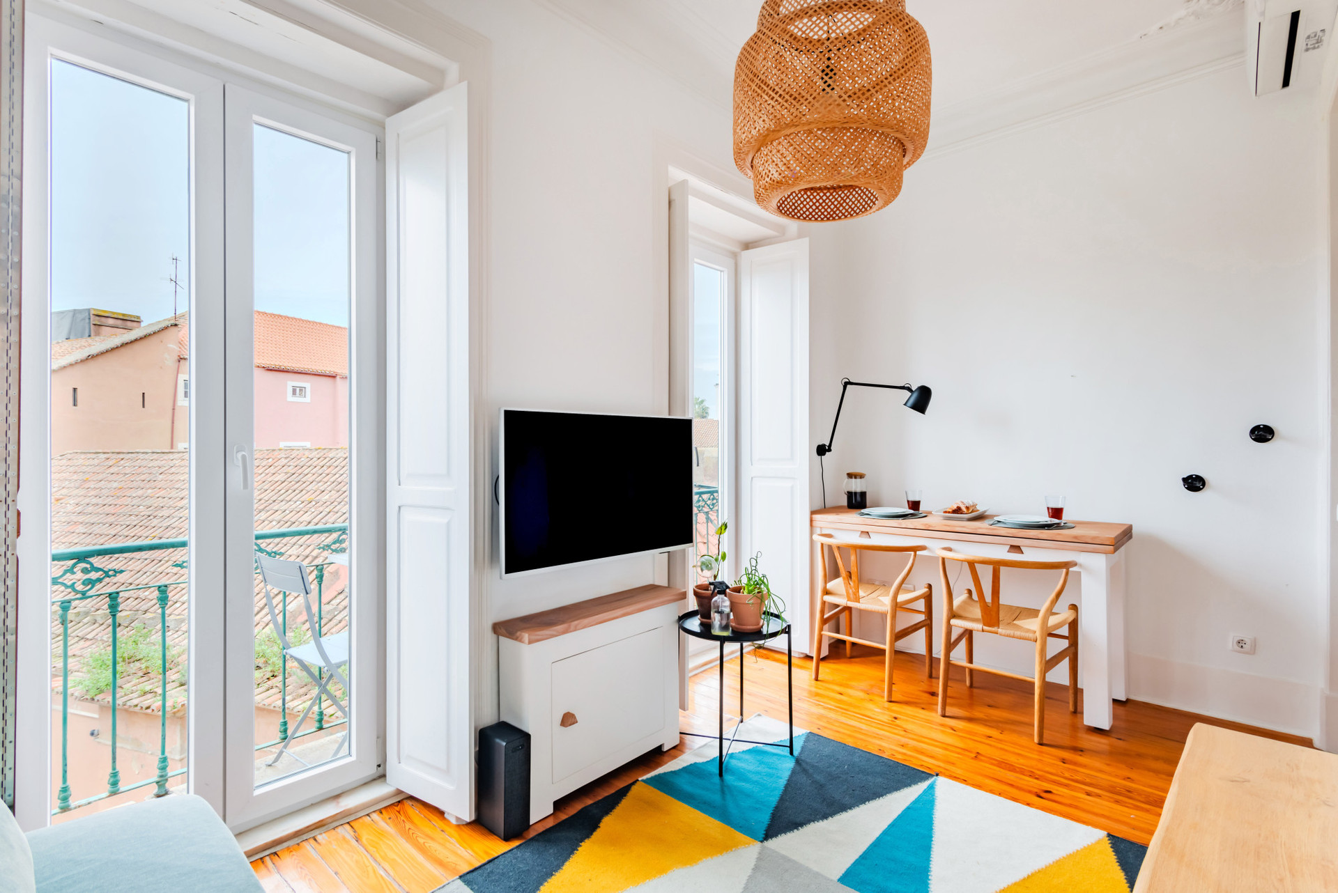 Living Room with a comfortable sofa, TV, Air Conditioning, Dining table for 2 and access to the balcony.