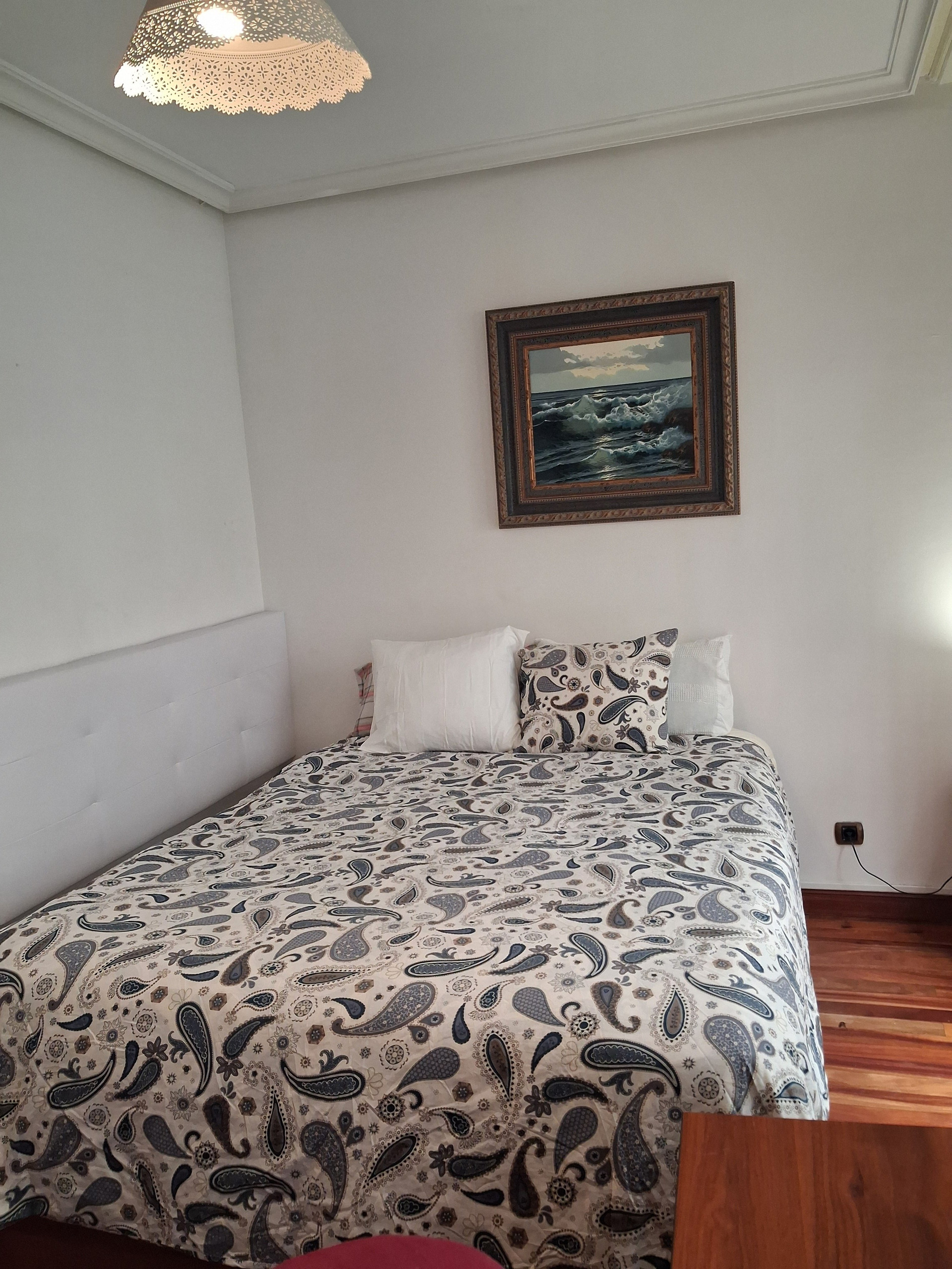 Double bed with framed seascape