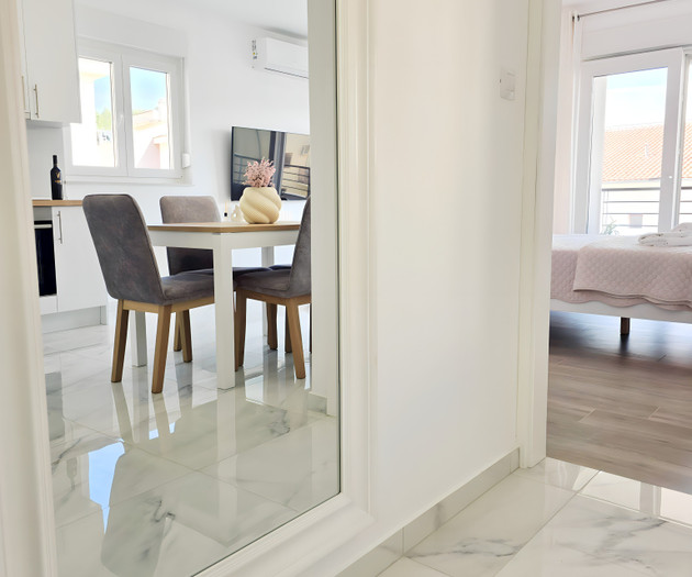 Mirror reflecting dining and bedroom