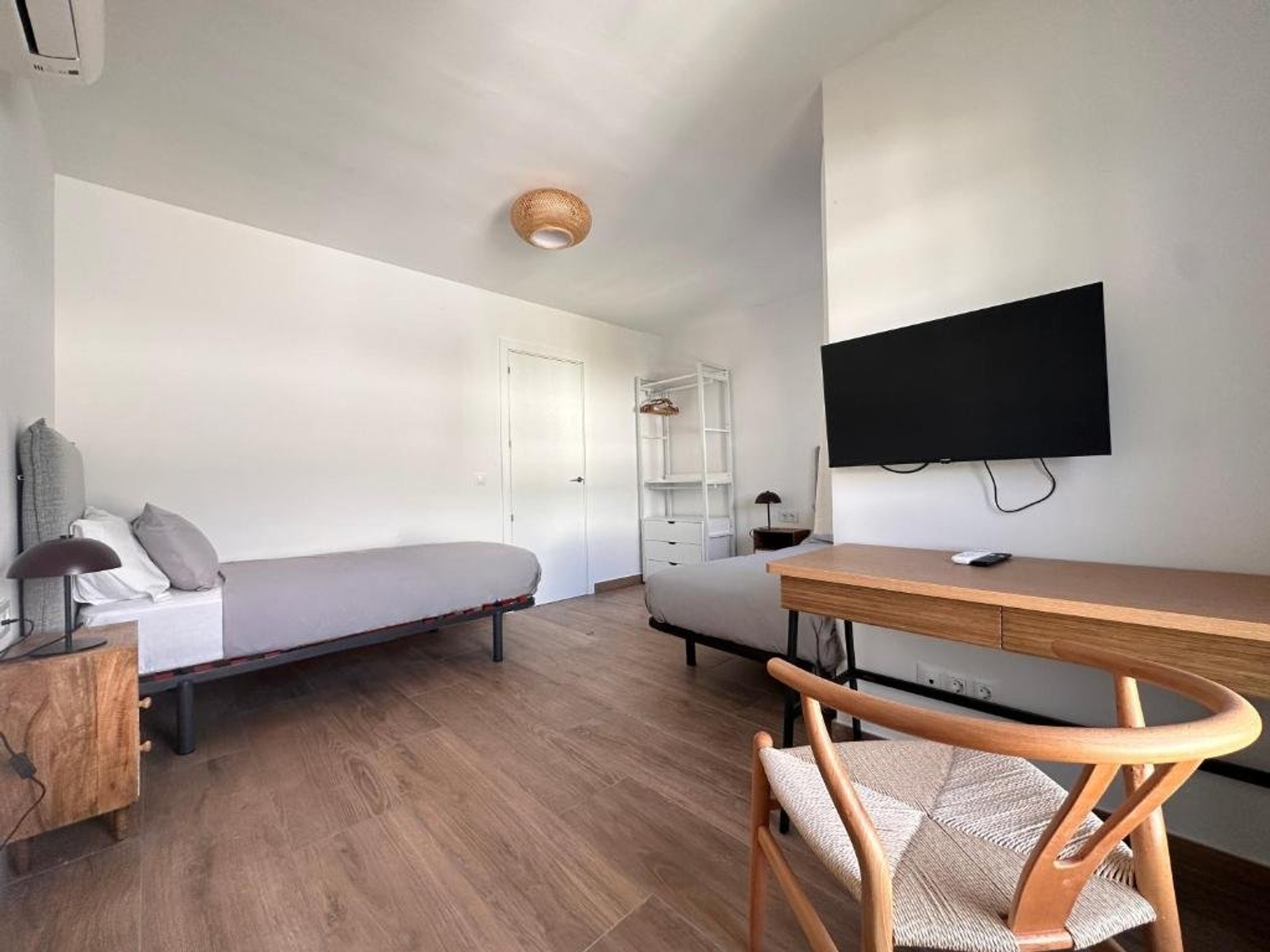 Twin bedroom with desk and TV