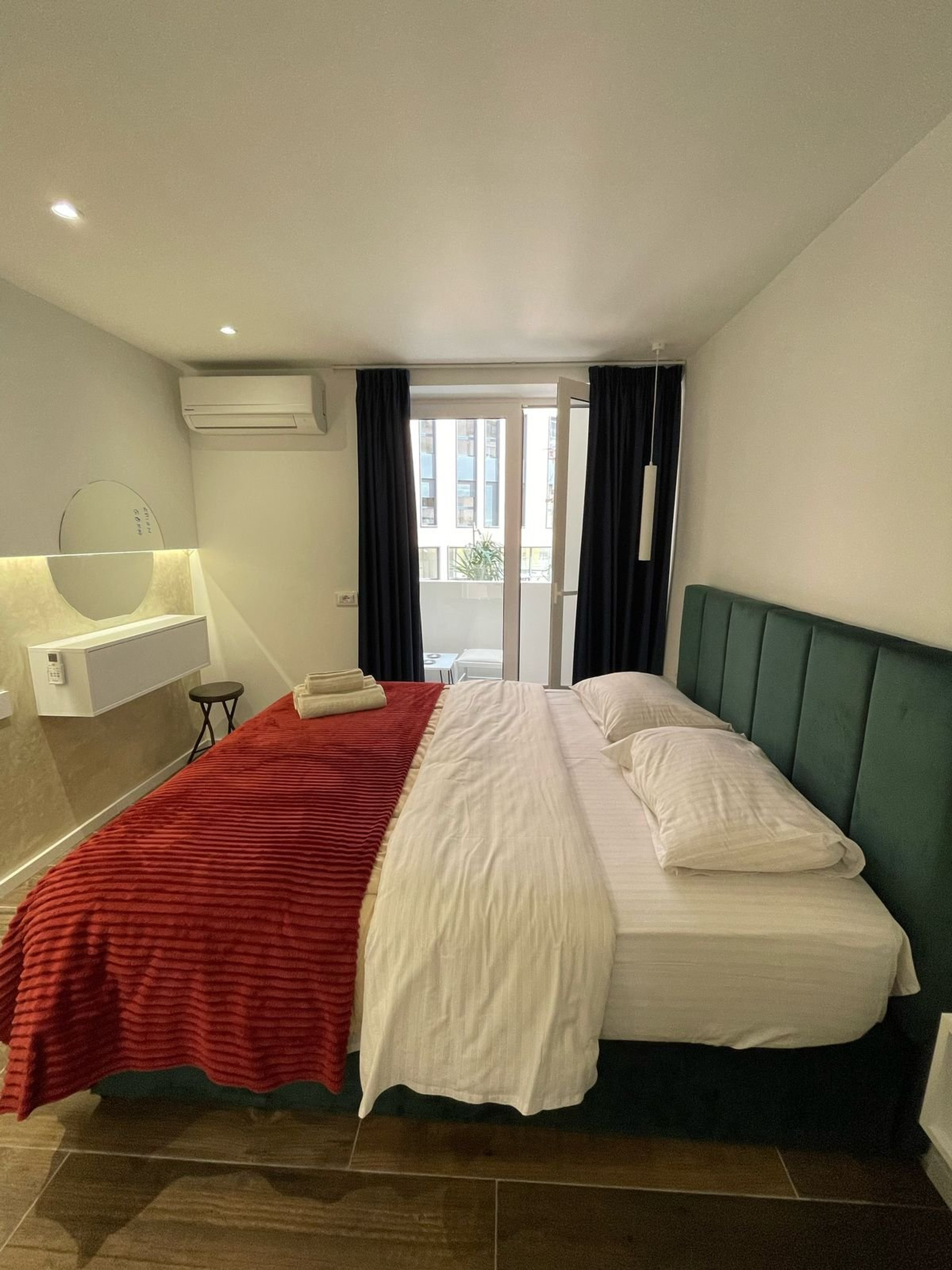 Bed with balcony door and red throw