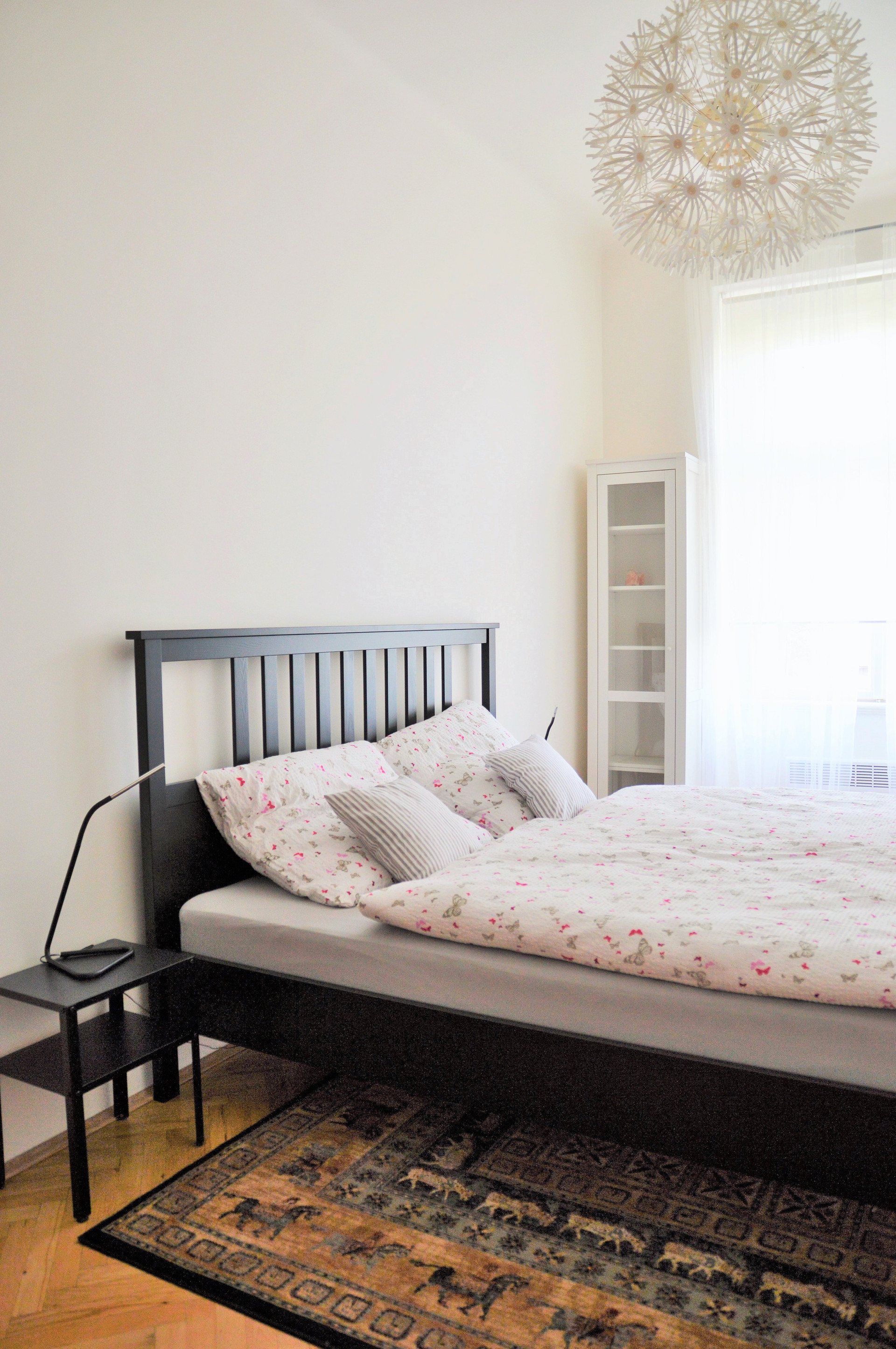 Bright bedroom with dark bed