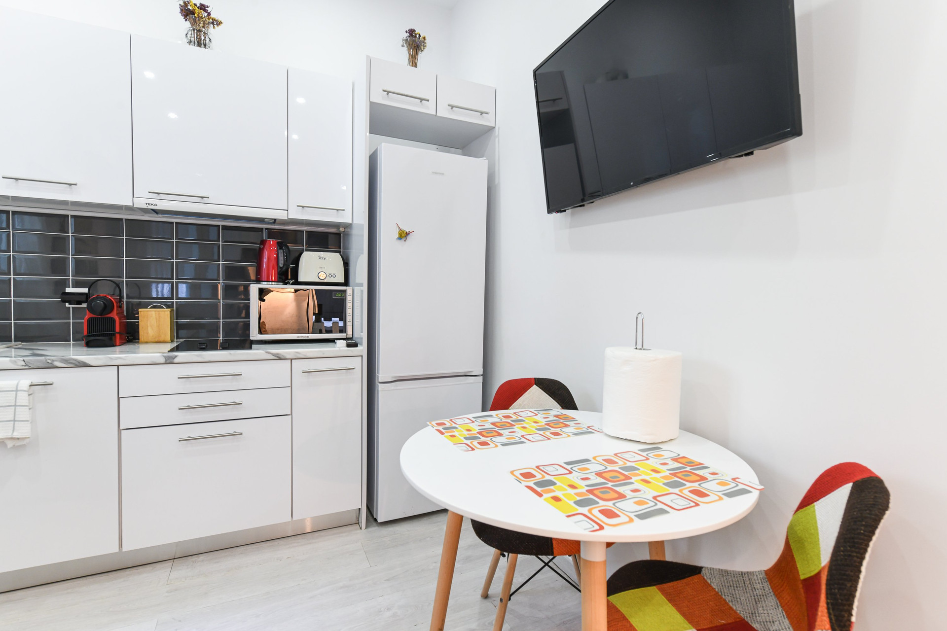White kitchen with dining table TV