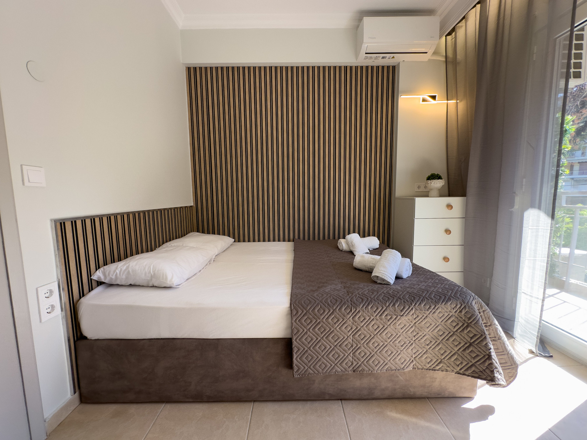 Spacious bedroom with striped accent wall