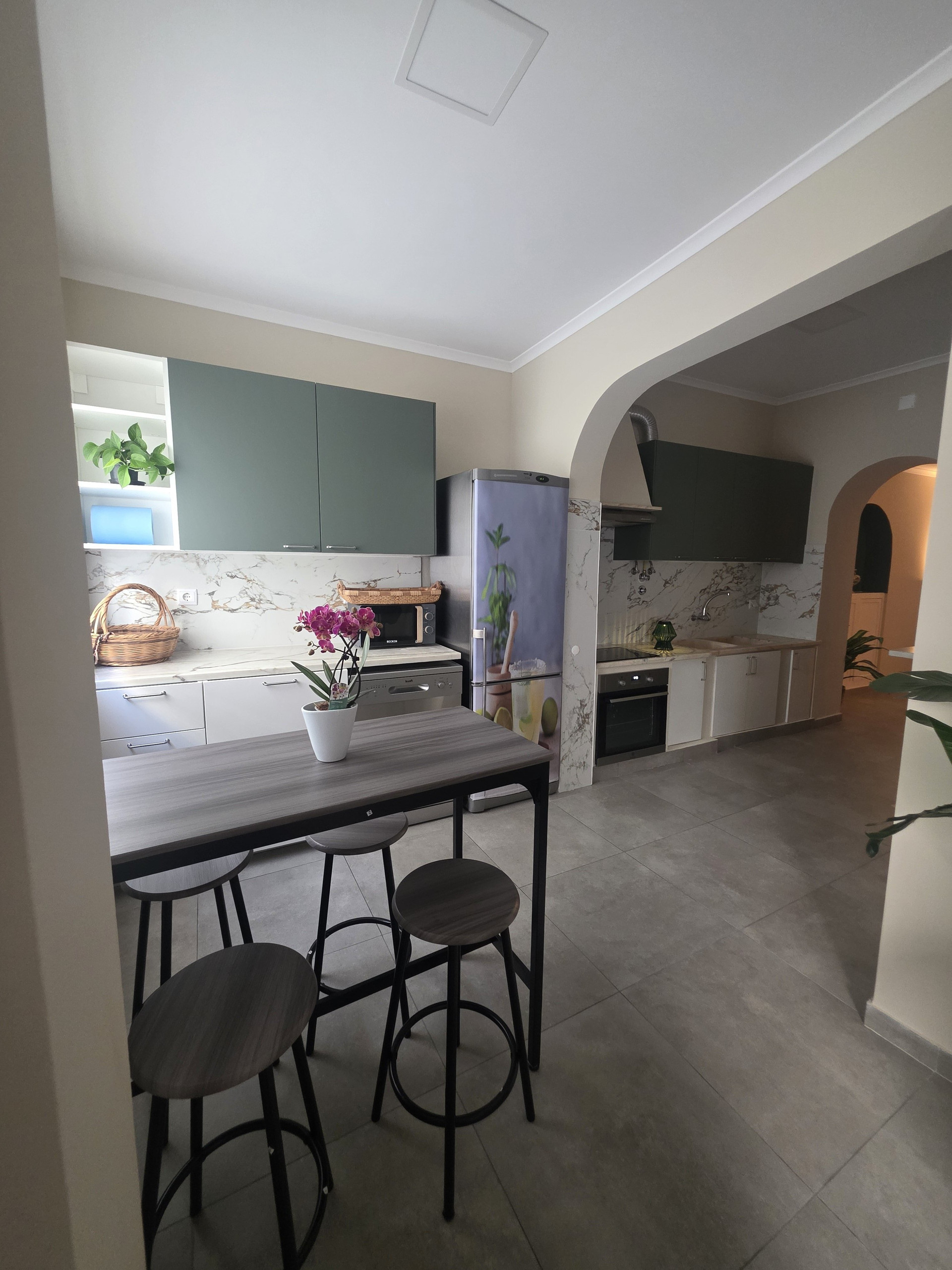 Modern kitchen with bar stools and arch